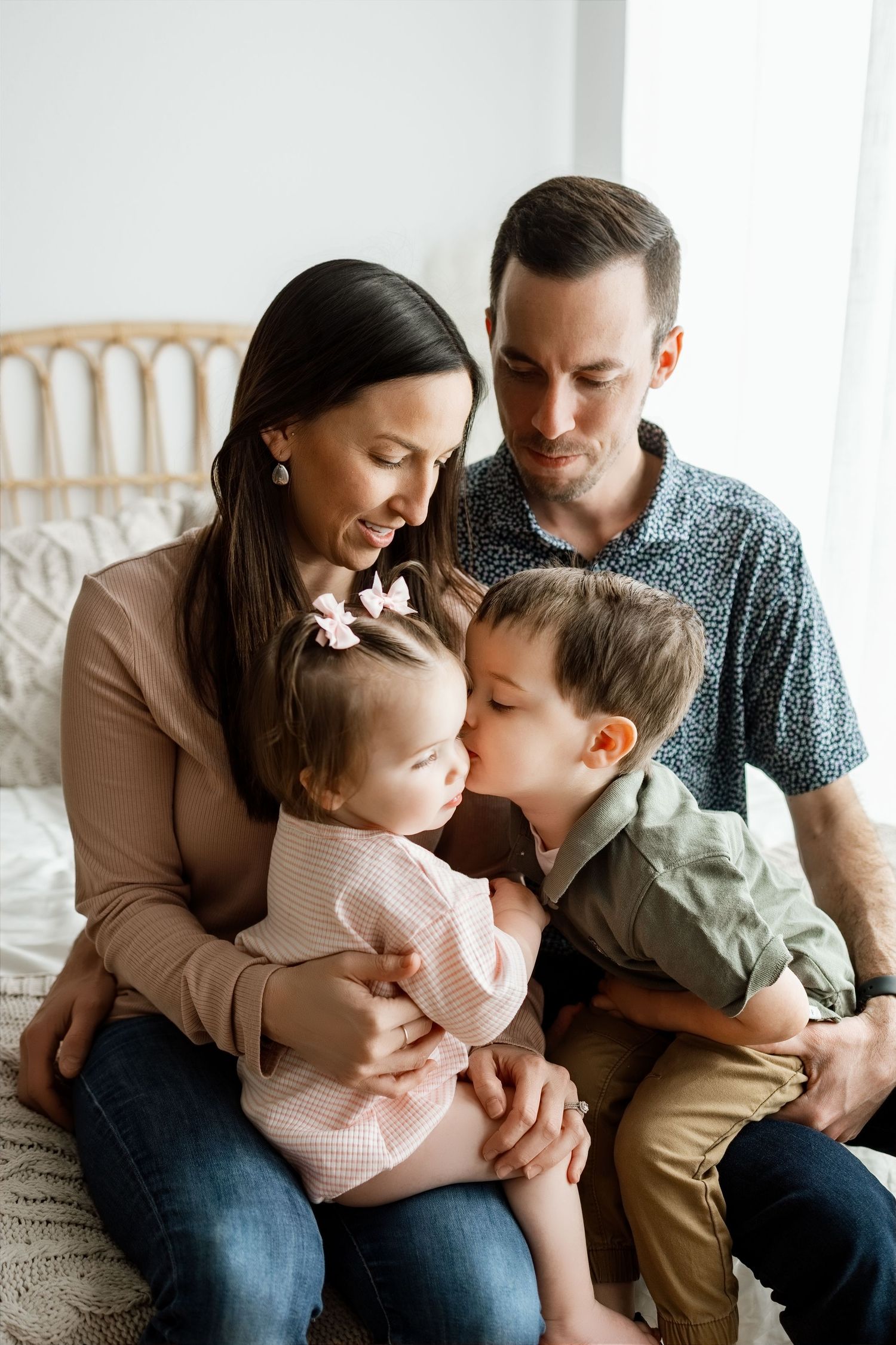 Family of four cuddling together during a baby milestone and cake smash photography session at the TLP studio