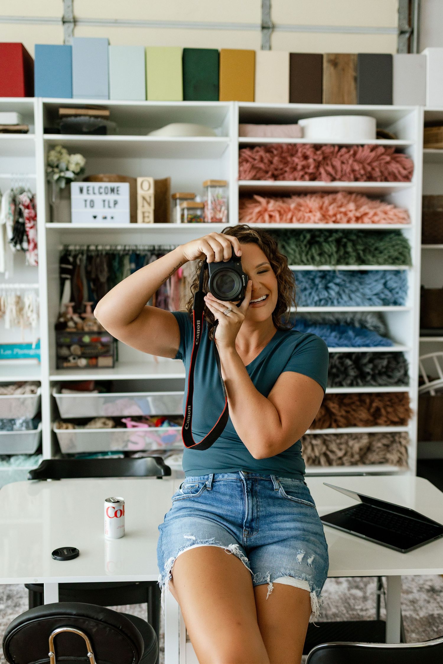 Tara smiling with her professional camera inside the Tara Lee Photography studio in Edwardsville