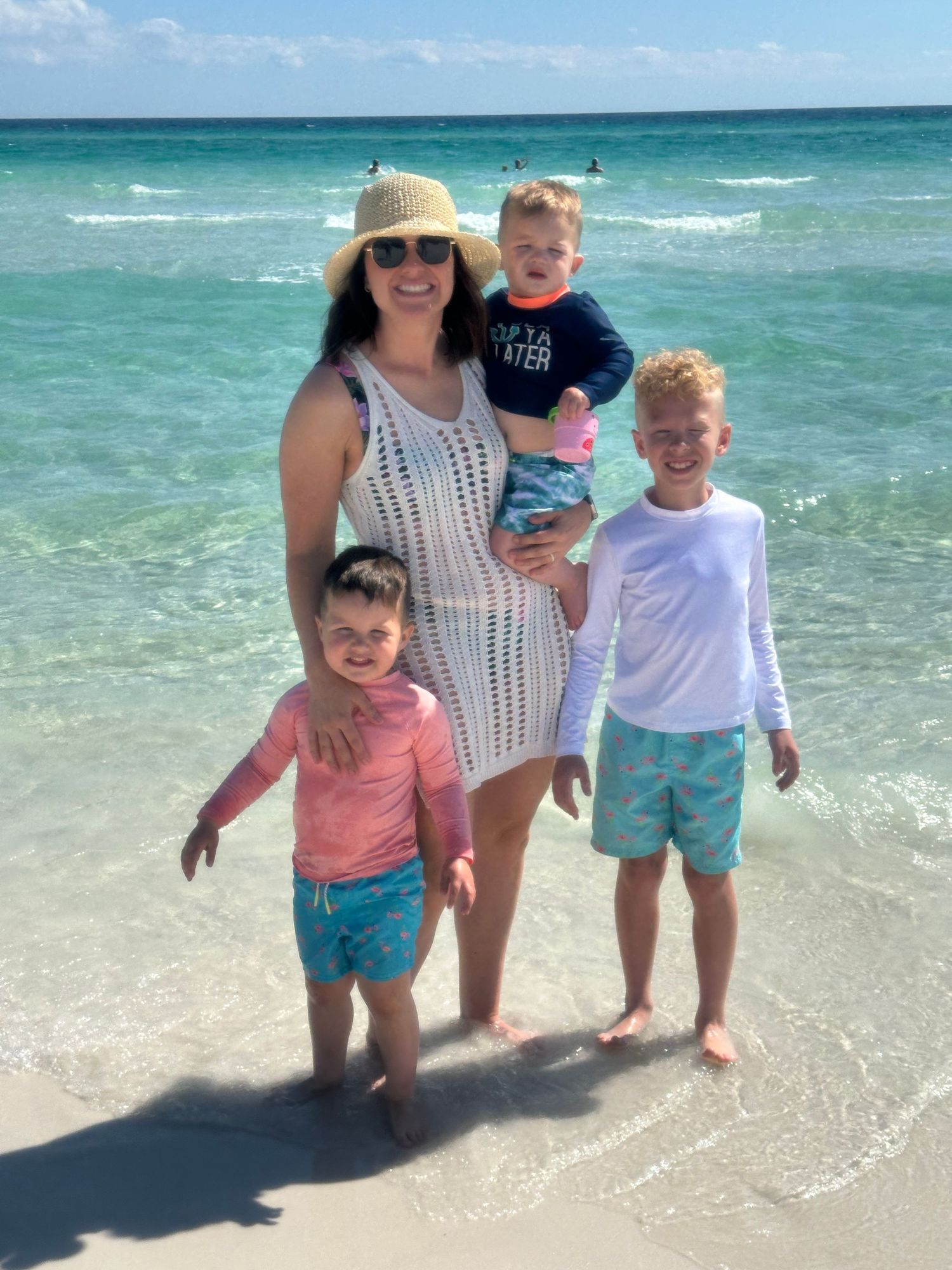Beach family portrait with tropical turquoise waters and white sand background.