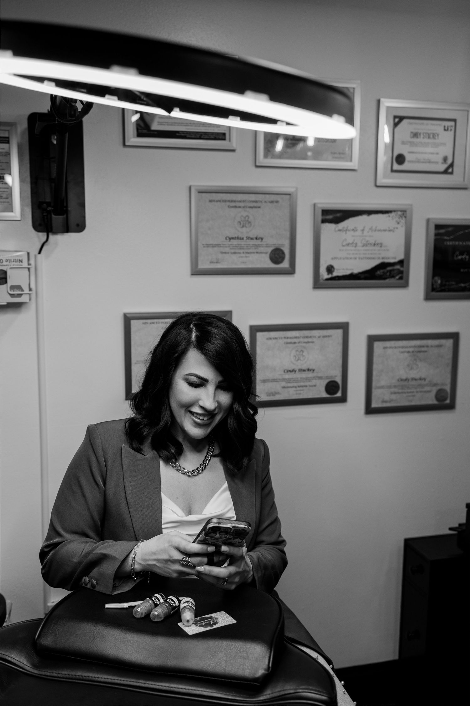 Black and white photos showing a professional workspace with certificates and lighting mounted on walls.