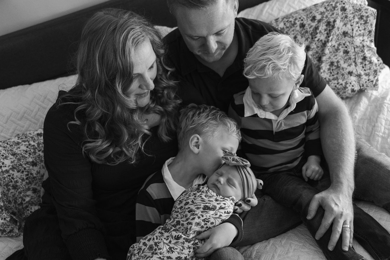 An intimate black and white family portrait taken indoors.