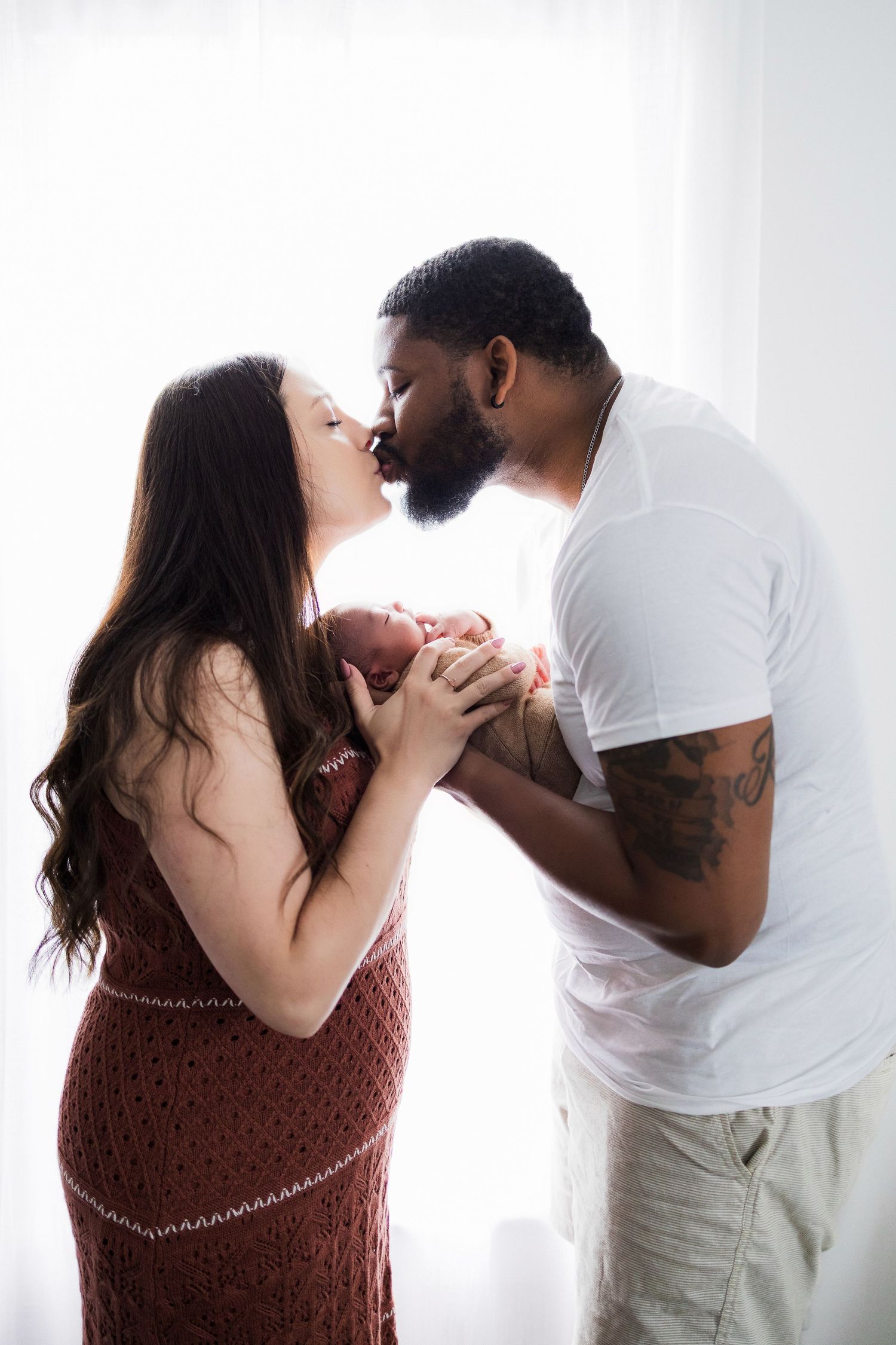 A romantic couple share a tender moment against a bright white backdrop.
