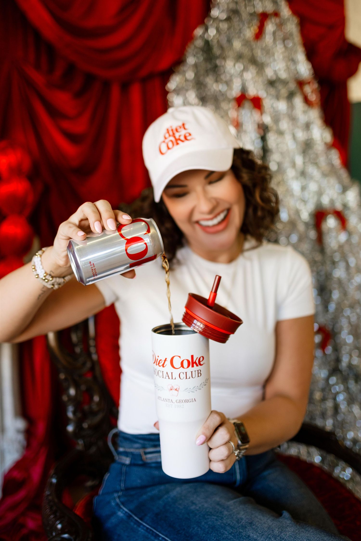 Brand photography featuring Diet Coke products and merchandise against sparkly red backdrop.