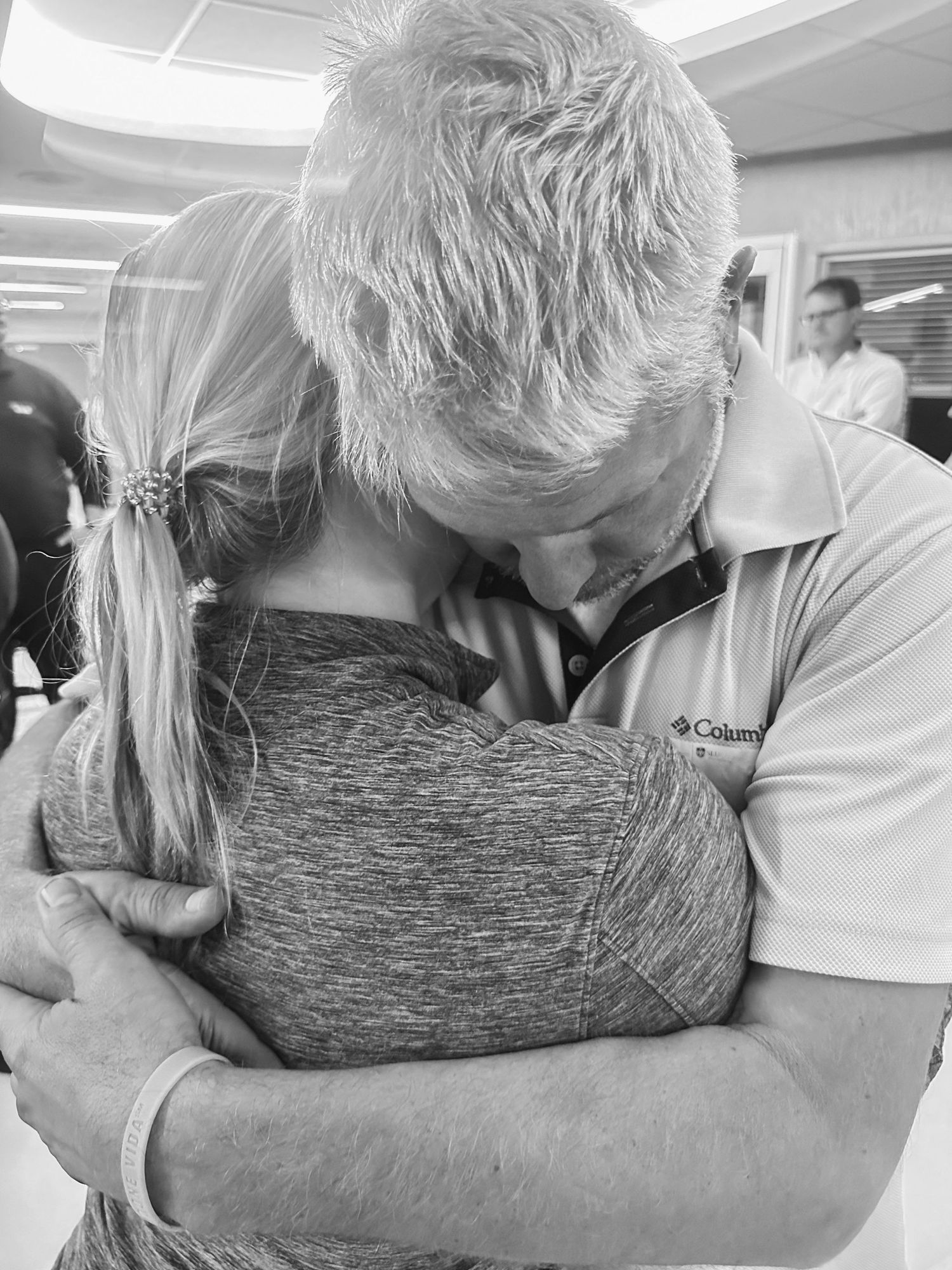 Tender moment of comfort and support shown through emotional embrace in medical setting.
