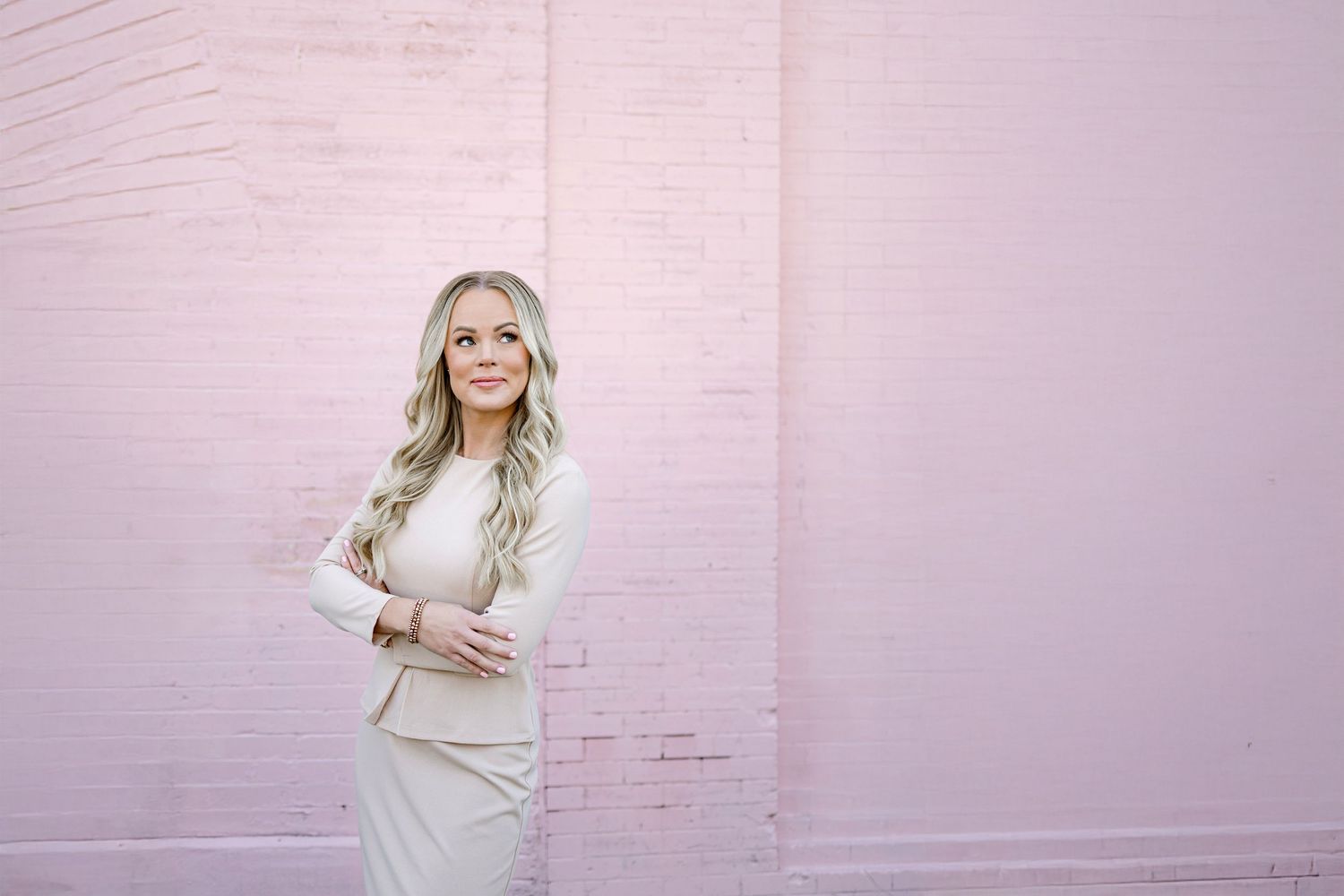 A series of fashion photos showing a person in a white sweater dress posing against a pink wall.