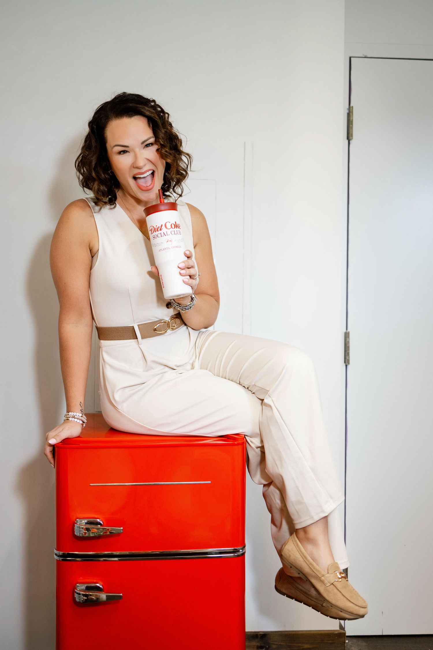 Lifestyle portrait session featuring bright red vintage refrigerator and white dress styling.