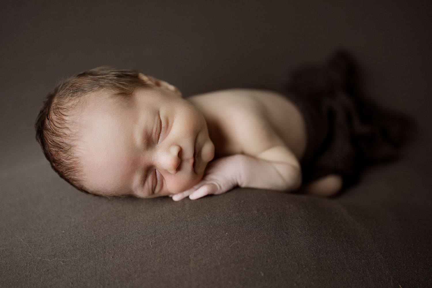 A collection of minimalist black and white newborn photography showing a sleeping baby in various gentle poses.
