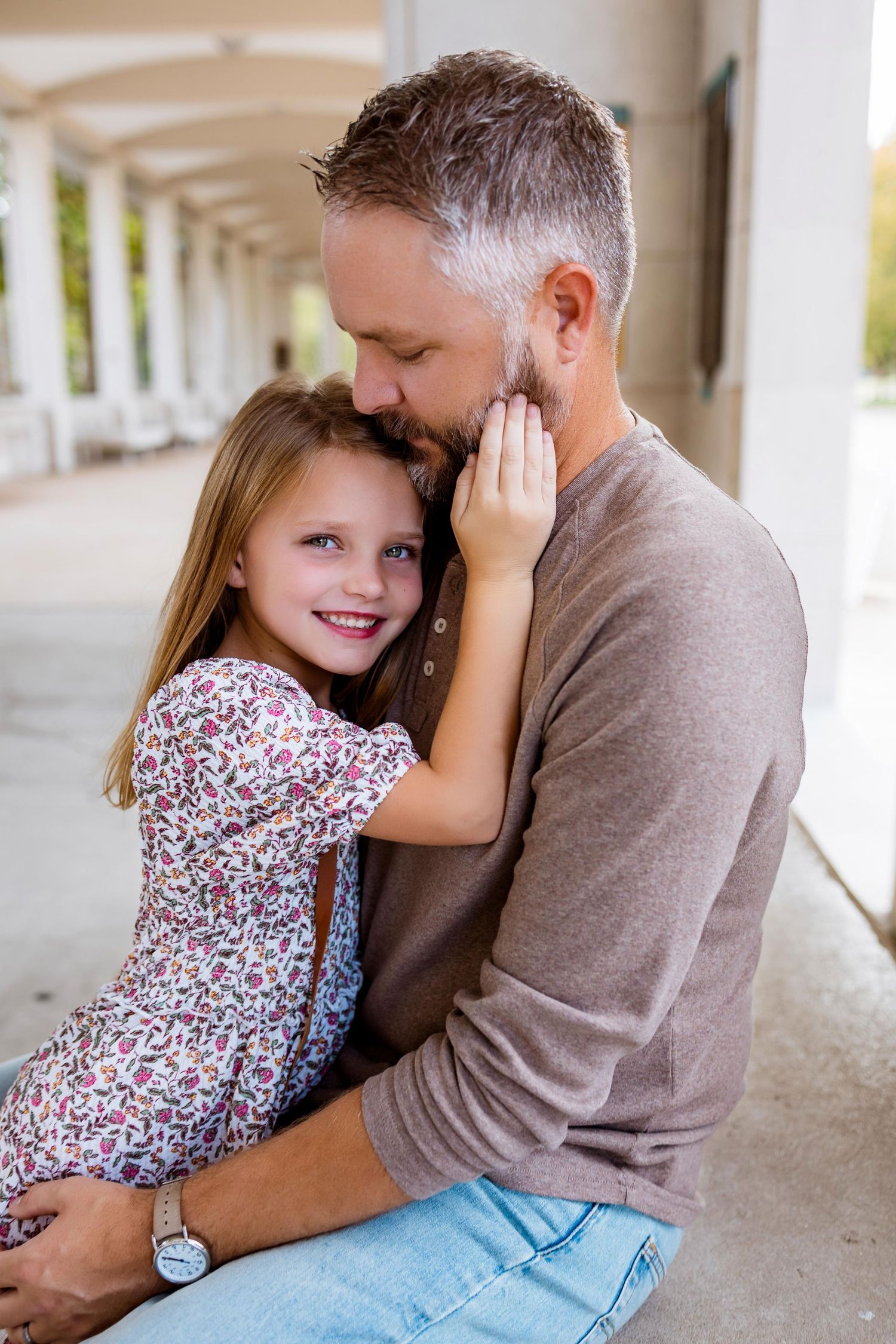 A tender moment captured between parent and child embracing in a covered outdoor walkway.