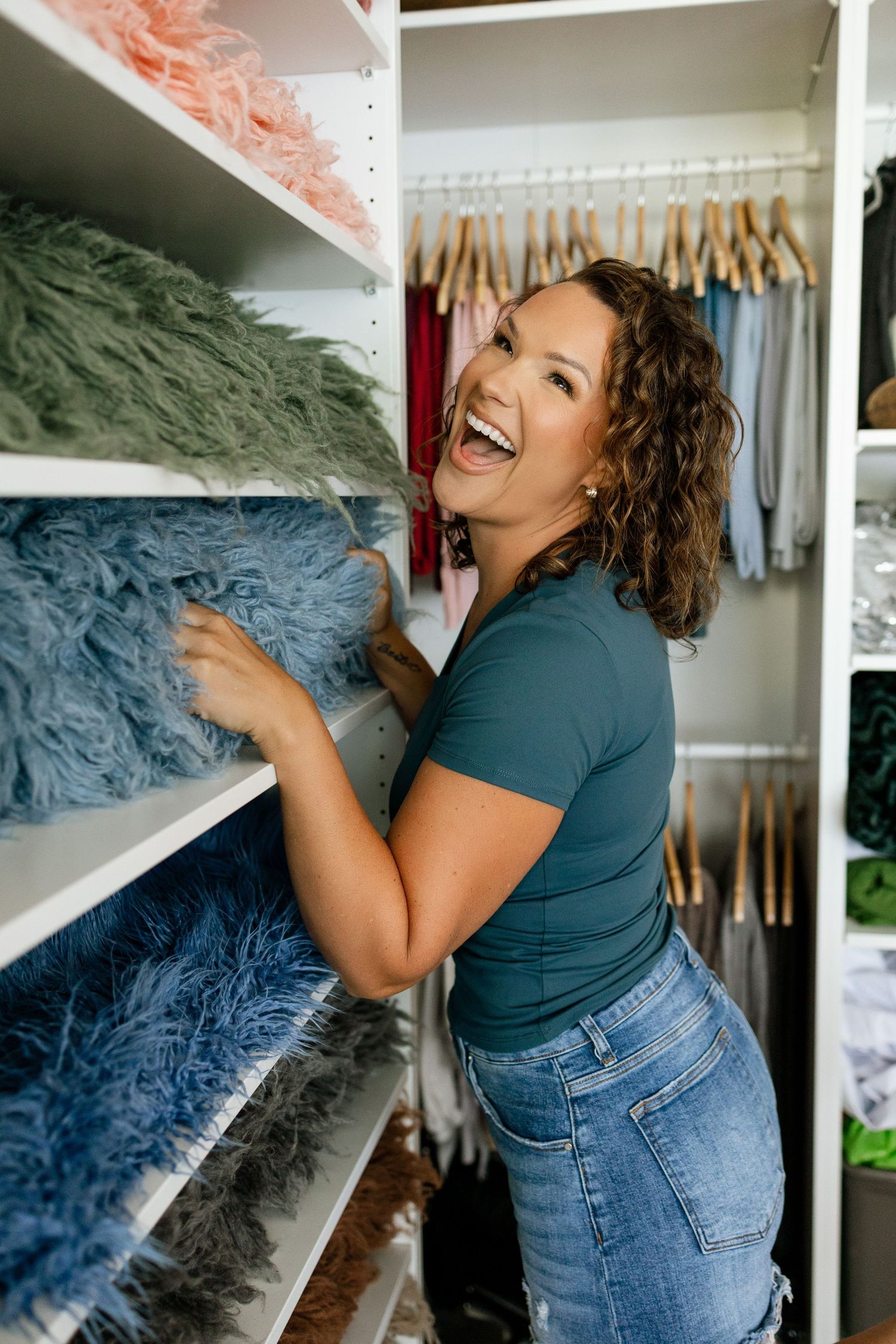 Tara organizing colorful newborn wraps and studio props at Tara Lee Photography in Edwardsville, Illinois