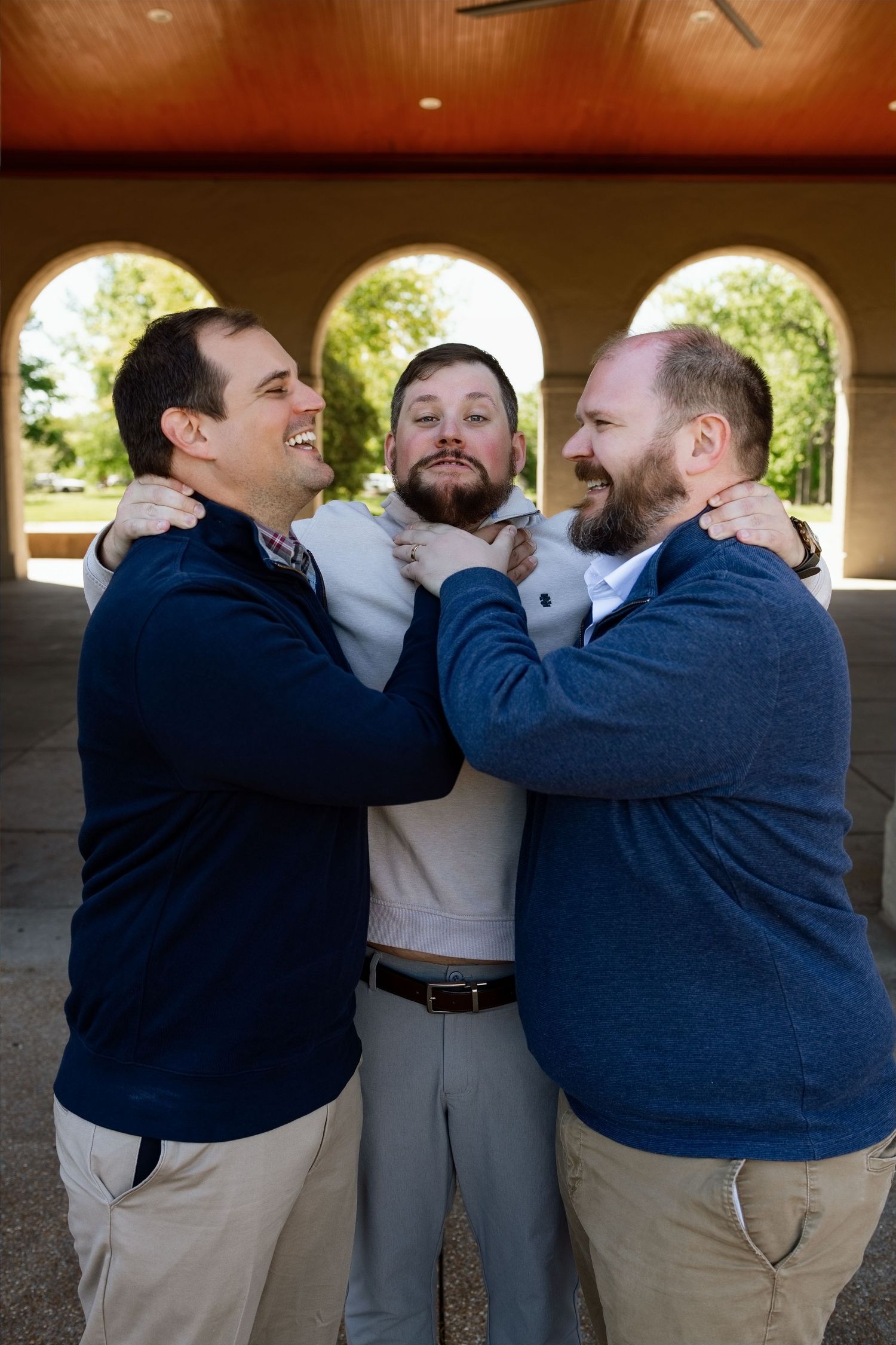 Three family members laughing and joking together during a personality-filled extended-family photography session