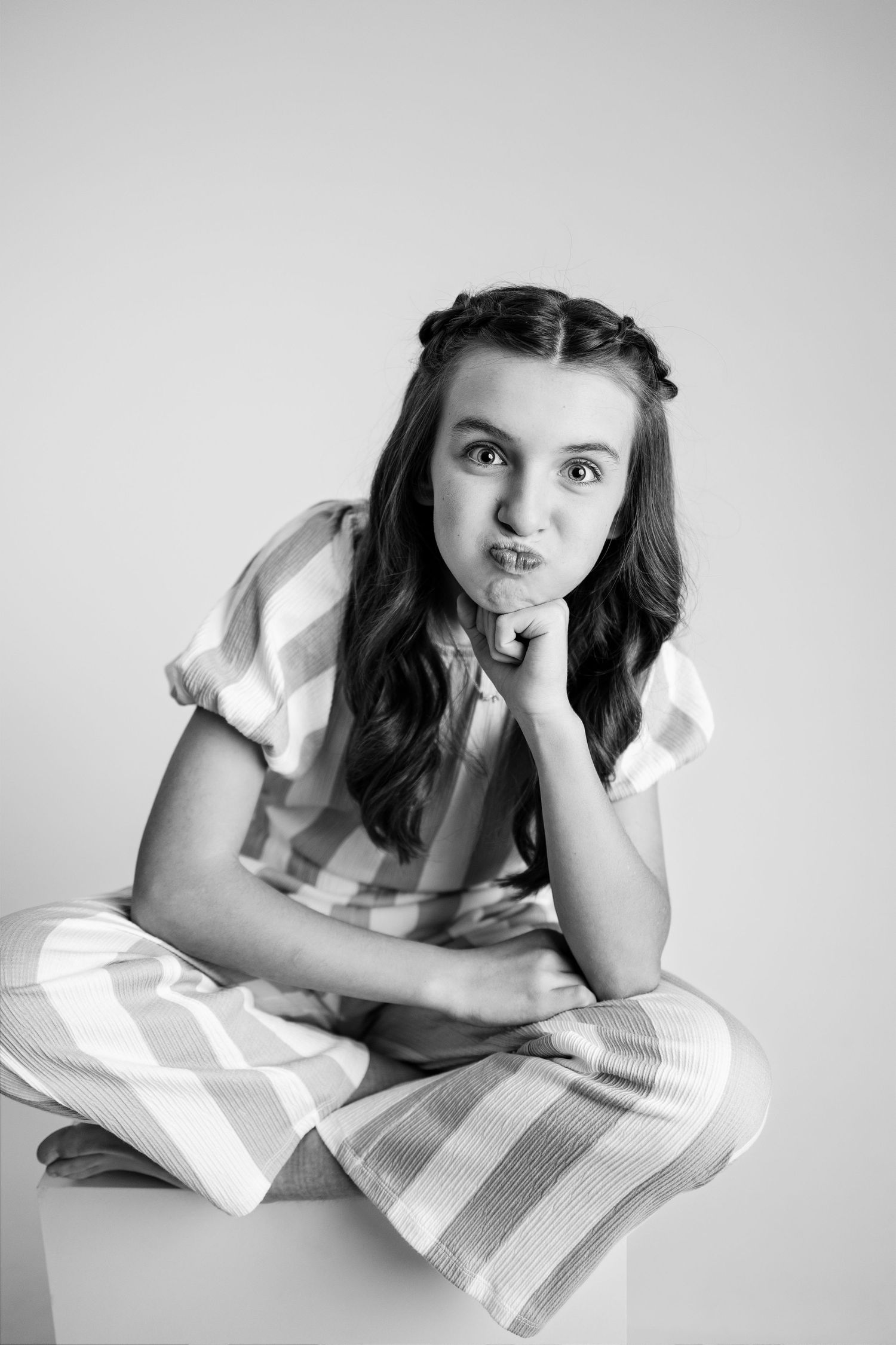 Black and white artistic photo series showing someone lying on a striped pillow in different relaxed poses.