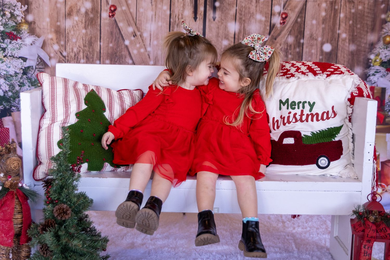 Children's feet dangle while sitting on a festive holiday bench with Christmas decorations in the background.