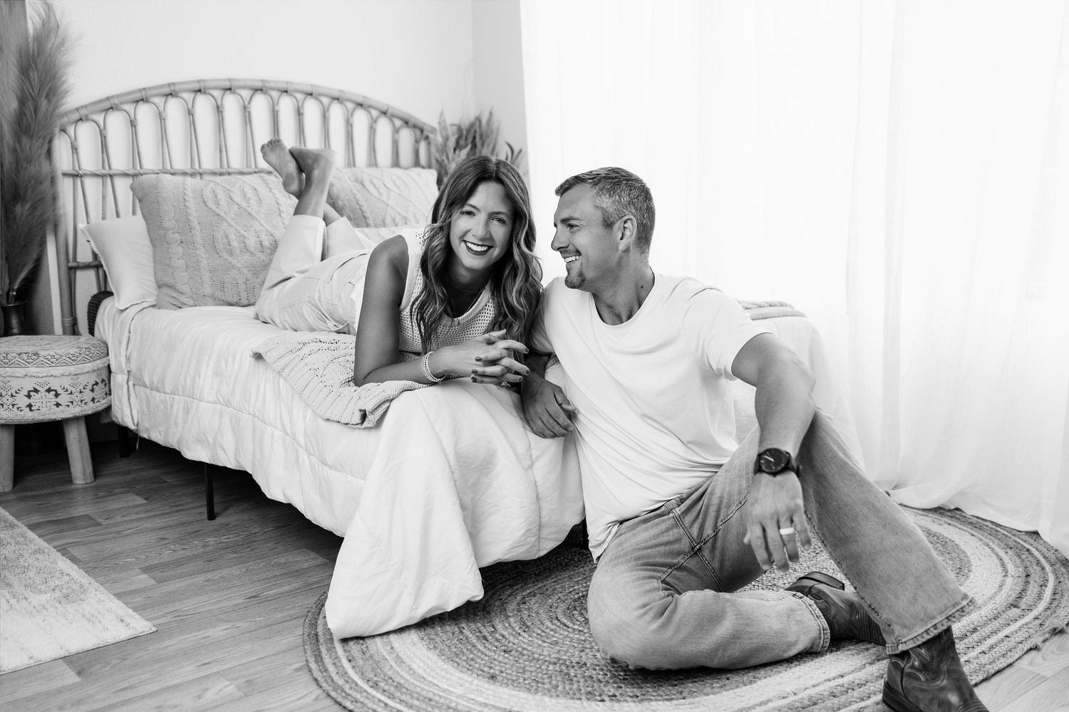 Black-and-white portrait of a couple laughing together in the lifestyle area of Tara Lee Photography’s Edwardsville studio