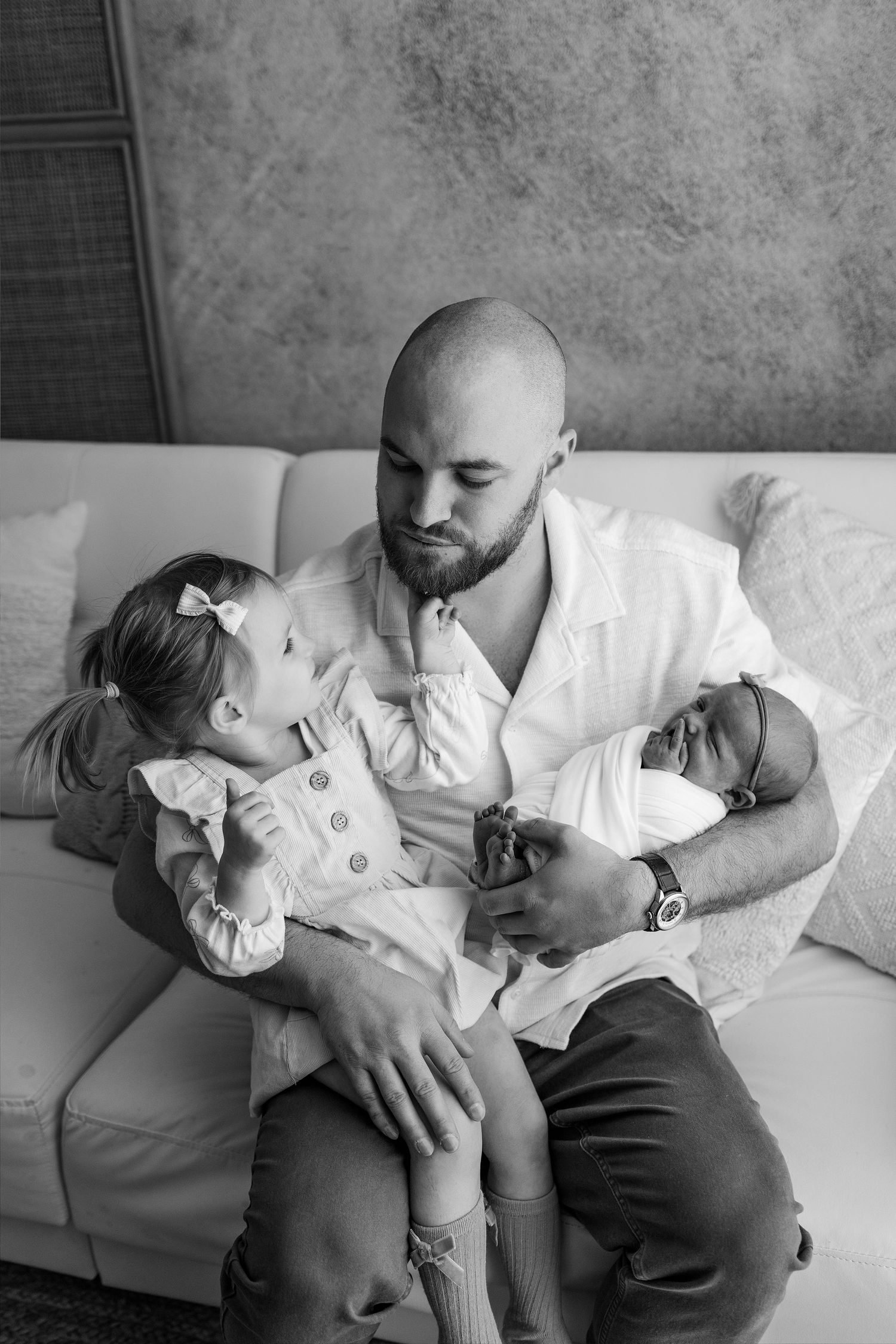 A tender black and white photo series showing a parent and child sharing affectionate moments together on a couch.