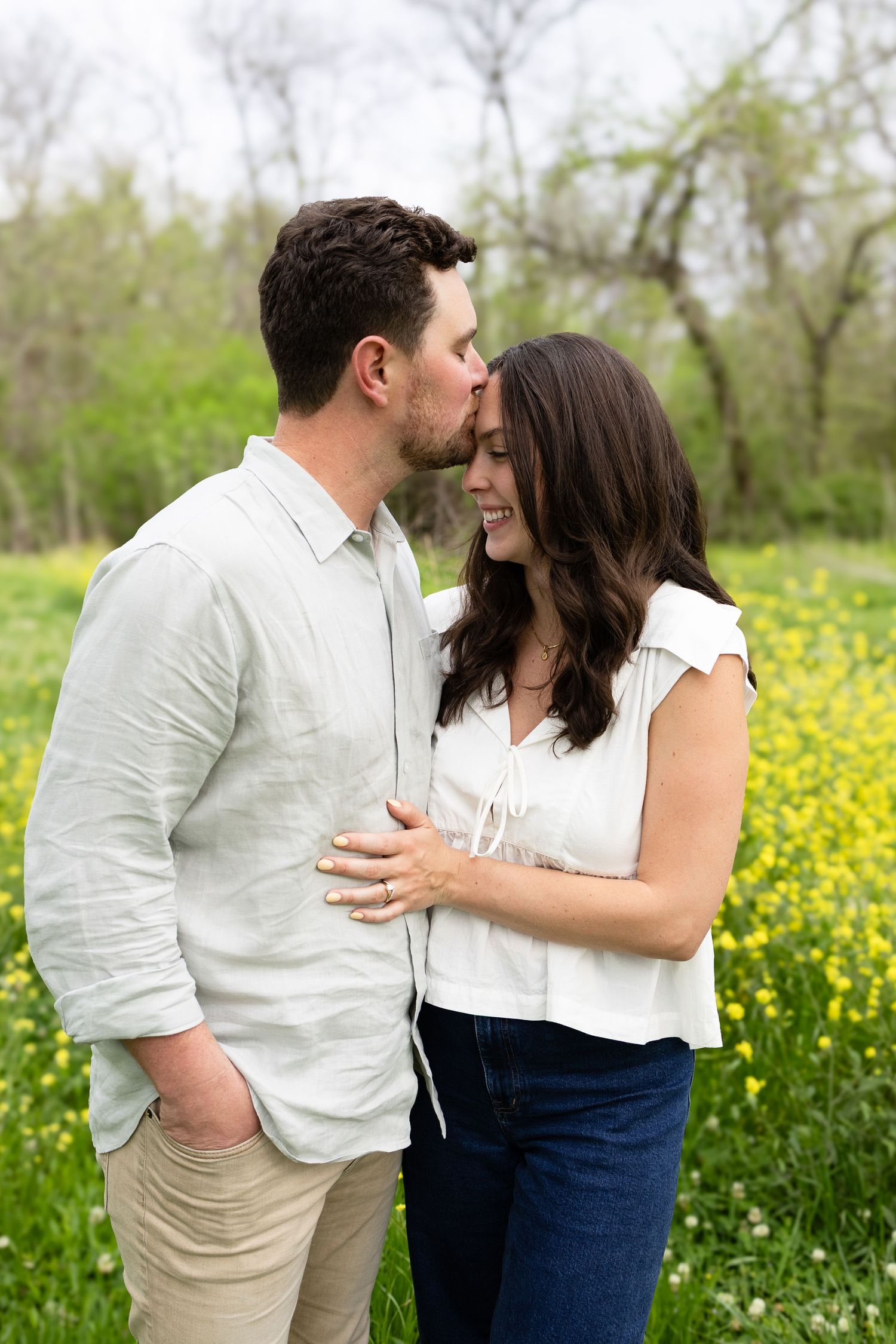 Romantic couple sharing tender moment in field of yellow wildflowers on sunny spring day.
