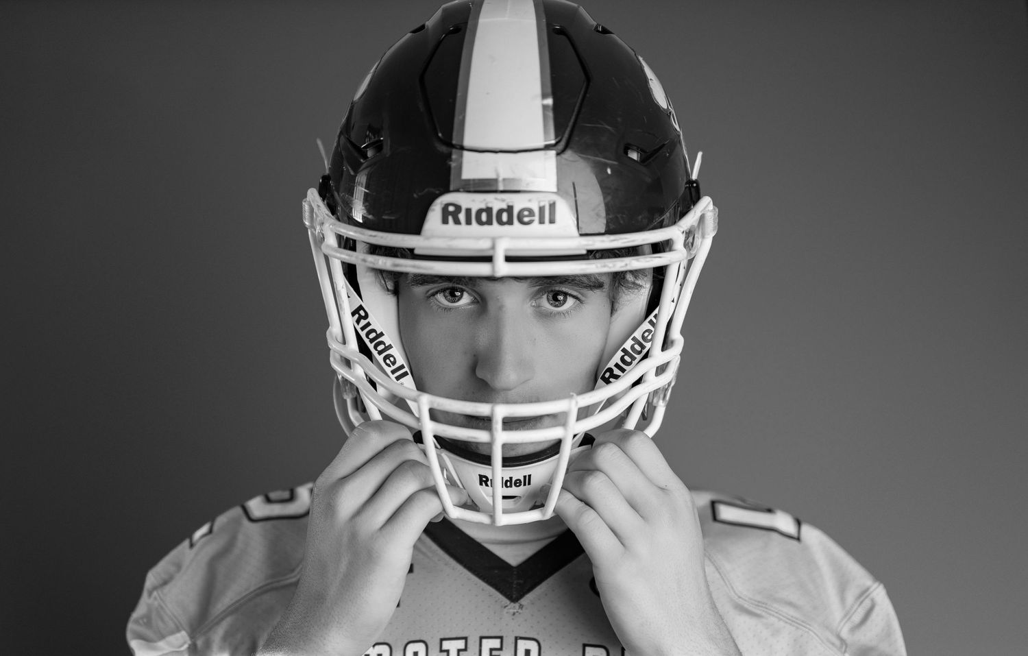 Football players in white helmets and uniforms shown in a black and white photo series.