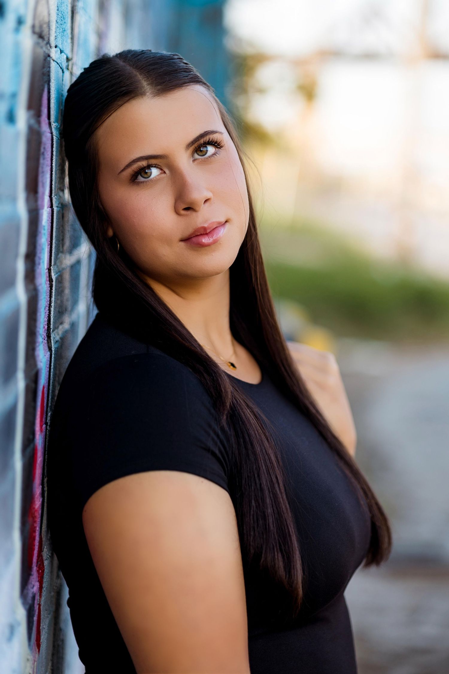 Portrait series showing a woman in a black top posing against a light background in an outdoor setting.