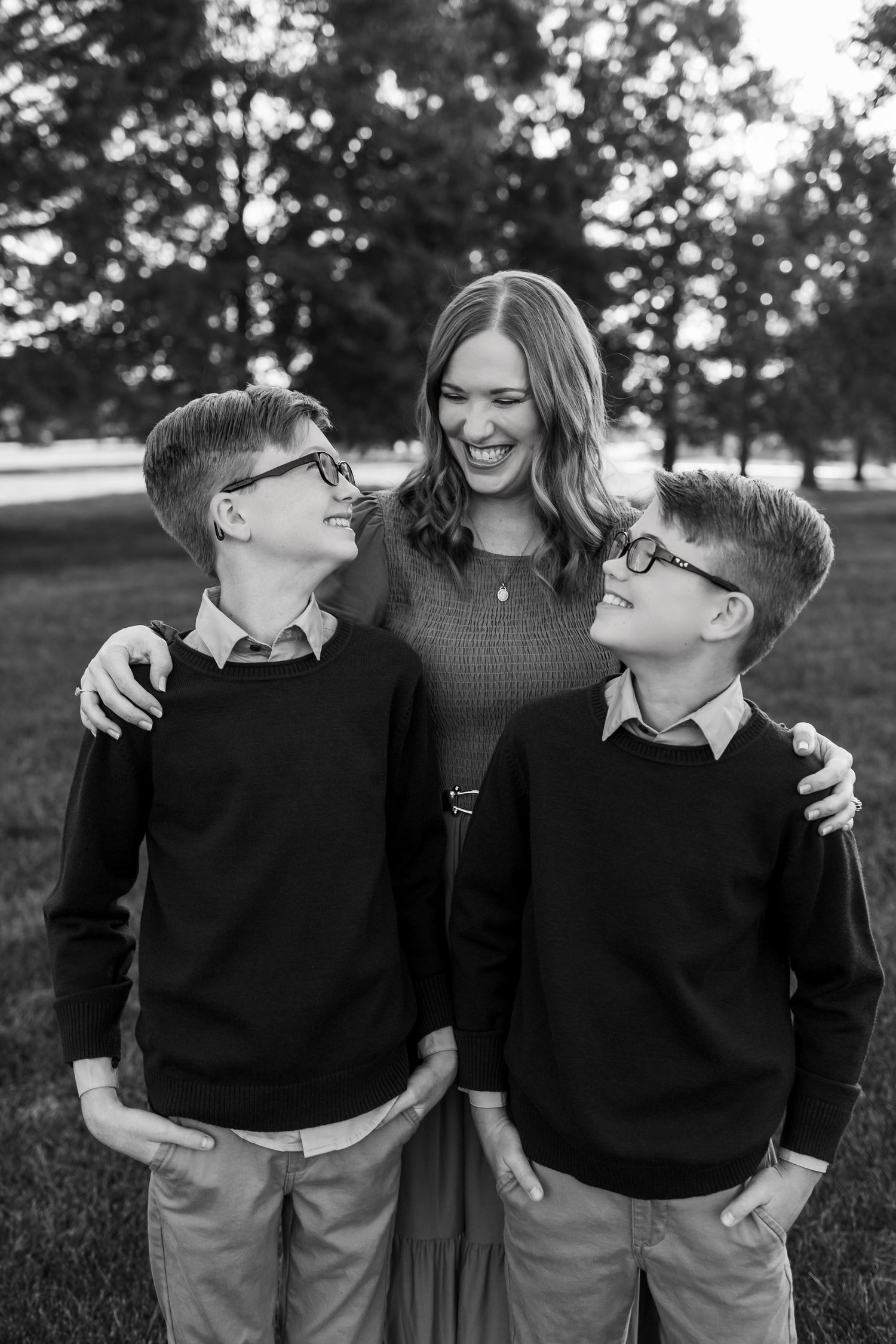 Black and white photo series showing joyful family moments outdoors with matching sweaters.