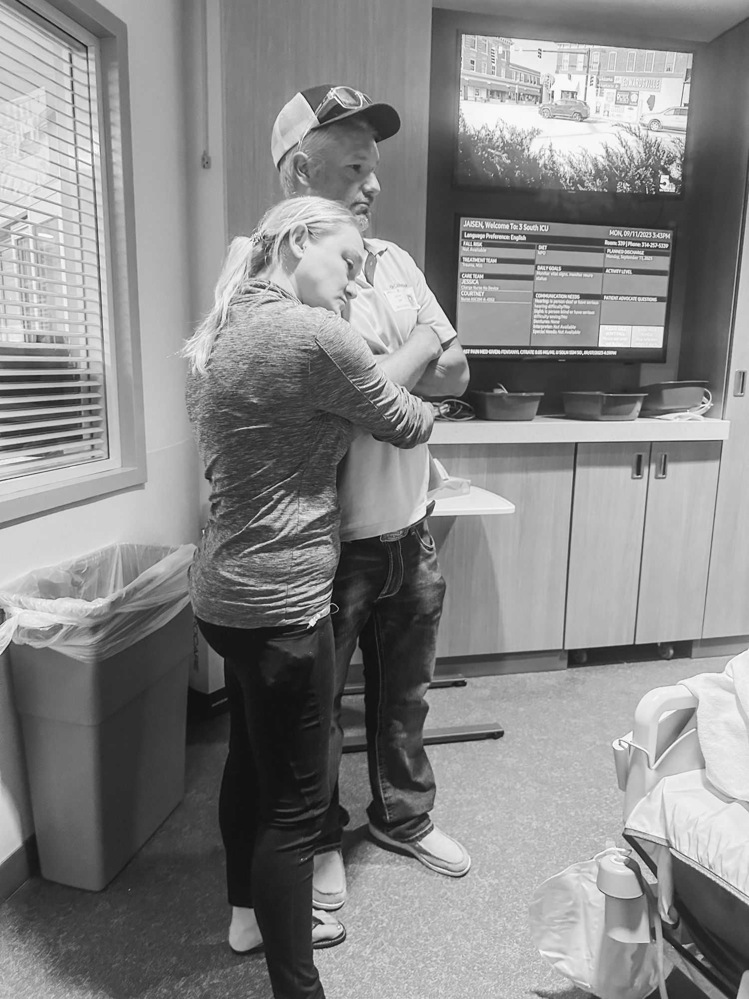 Intimate moment shared between two people embracing in medical office setting.