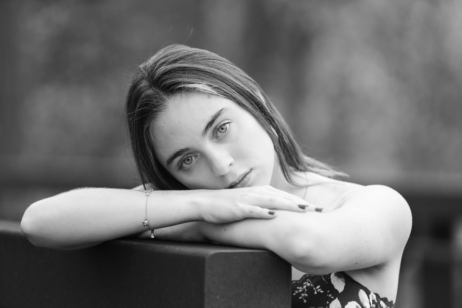 Black and white portrait showing contemplative pose resting on arms.