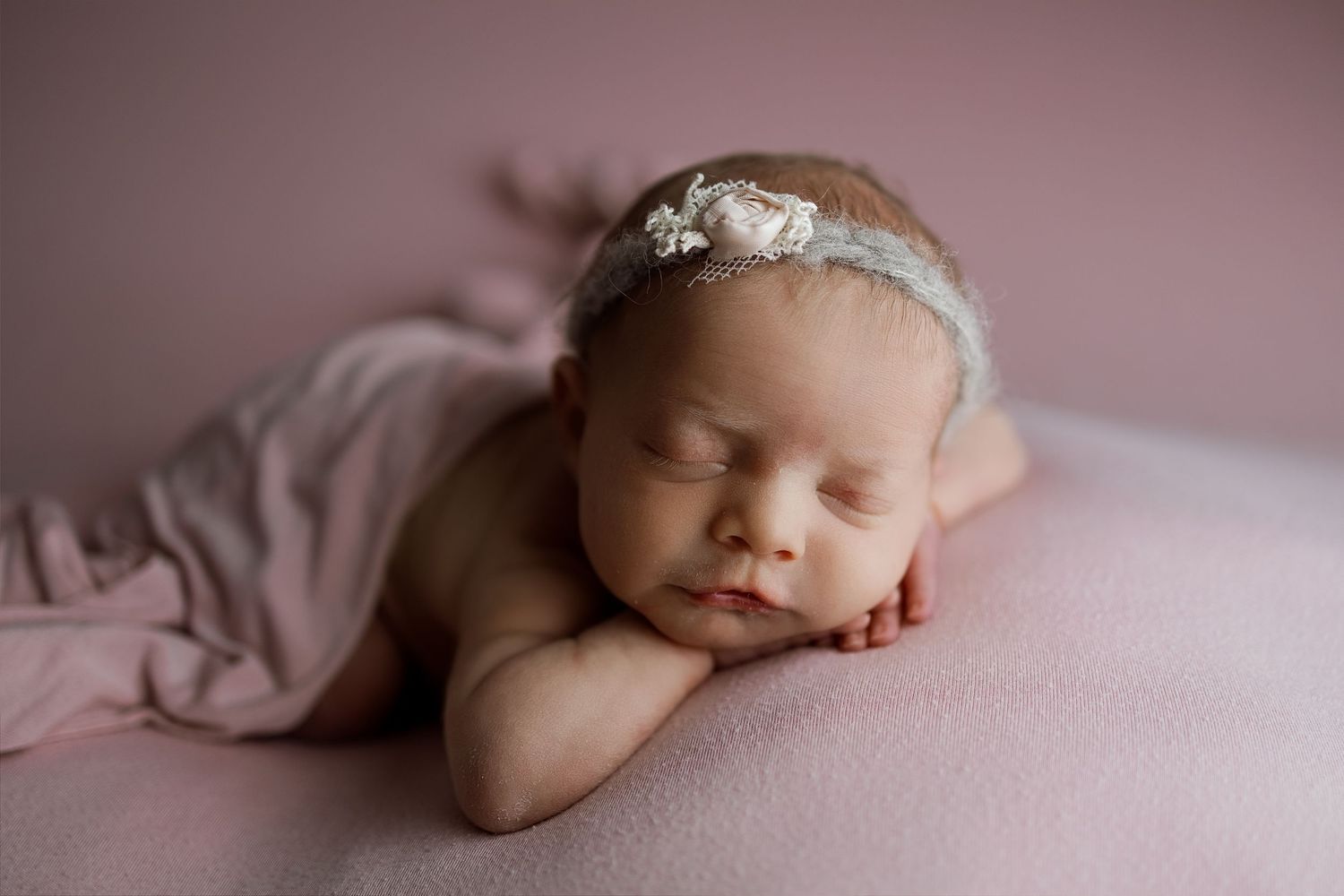 Collage of newborn baby photography in soft pink tones showing peaceful sleeping poses and delicate details.