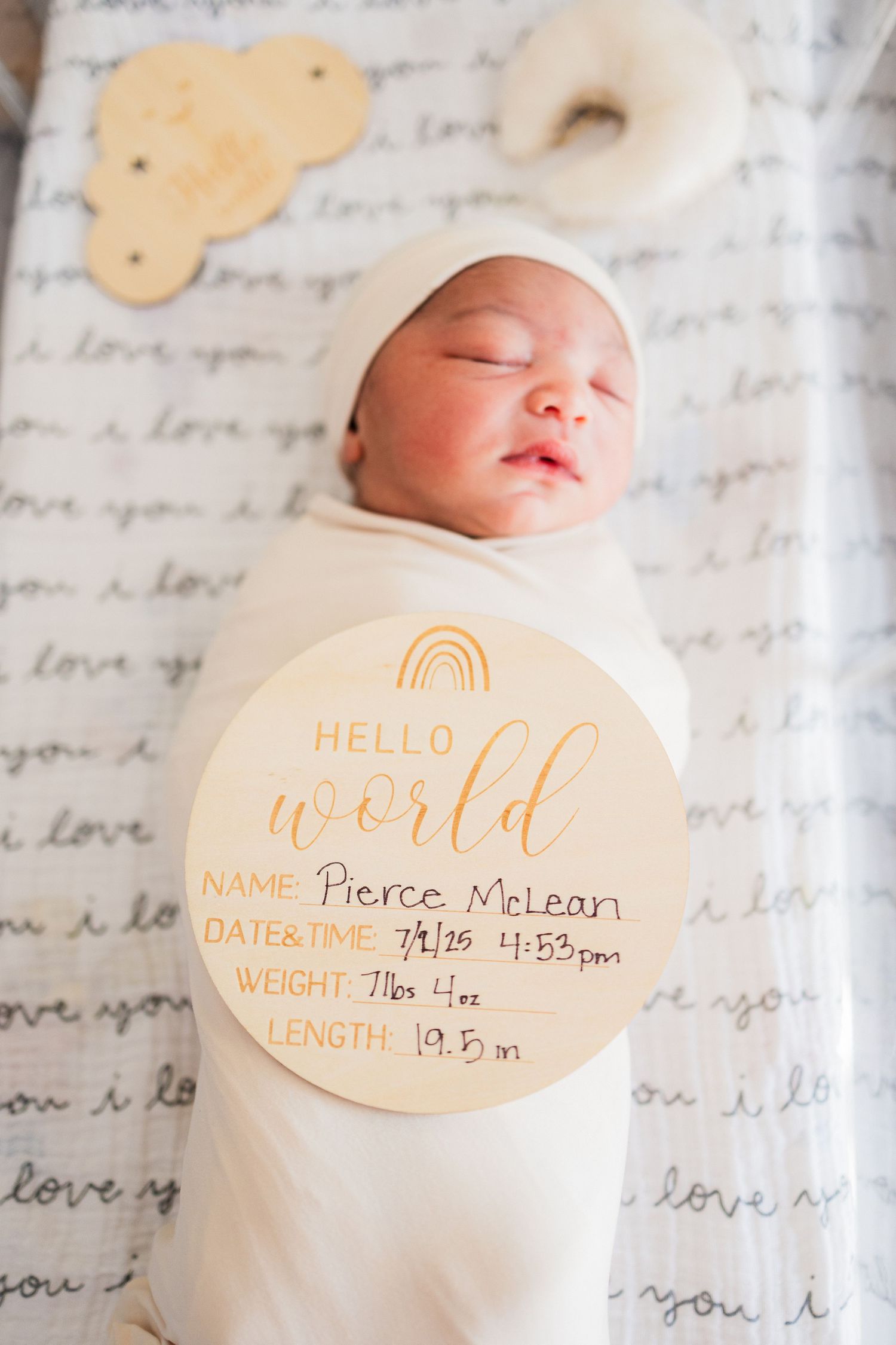 Newborn baby sleeping on handwritten letter background with birth details displayed on decorative circular cards.