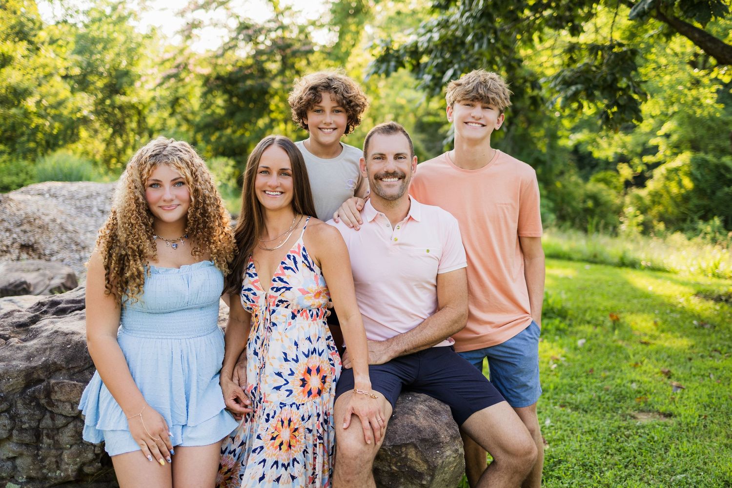 Five portrait photographs in an outdoor garden setting with greenery and natural lighting in the background.