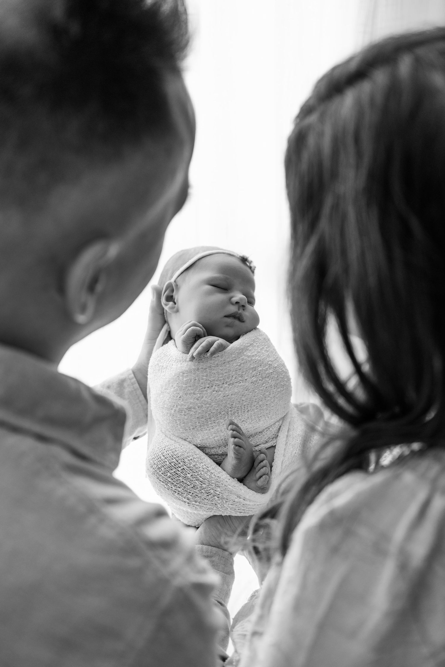 A series of black and white photos showing a tender moment between parent and baby in profile.