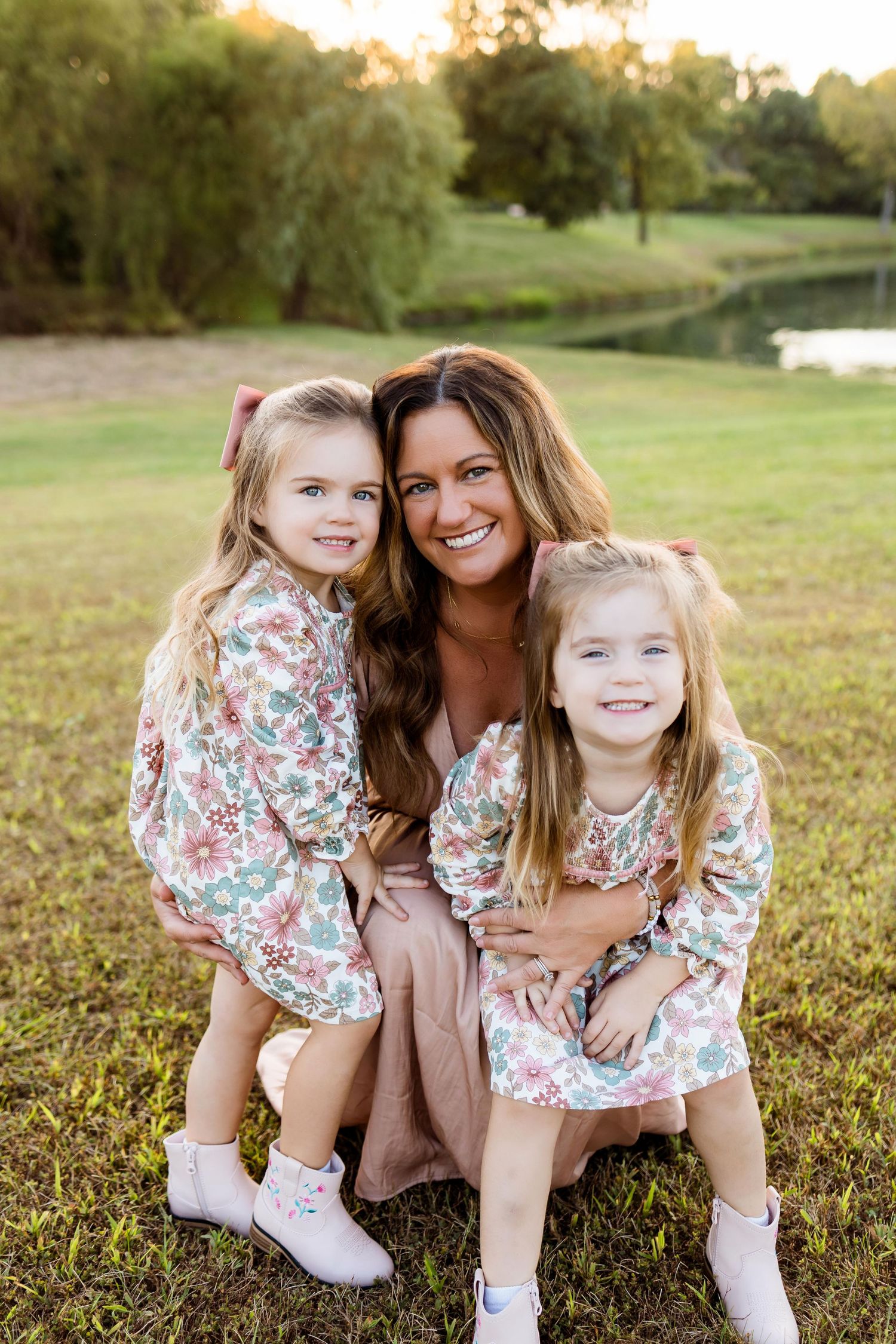 A joyful outdoor family portrait session on a grassy hill during golden hour.
