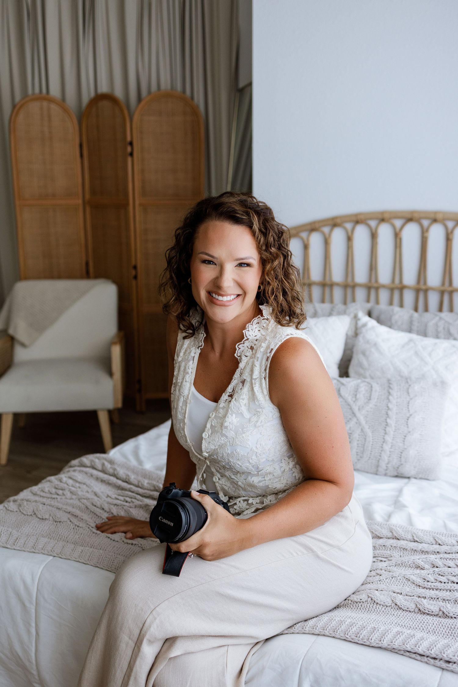 Edwardsville photographer Tara seated with her camera in the lifestyle area of the Tara Lee Photography studio