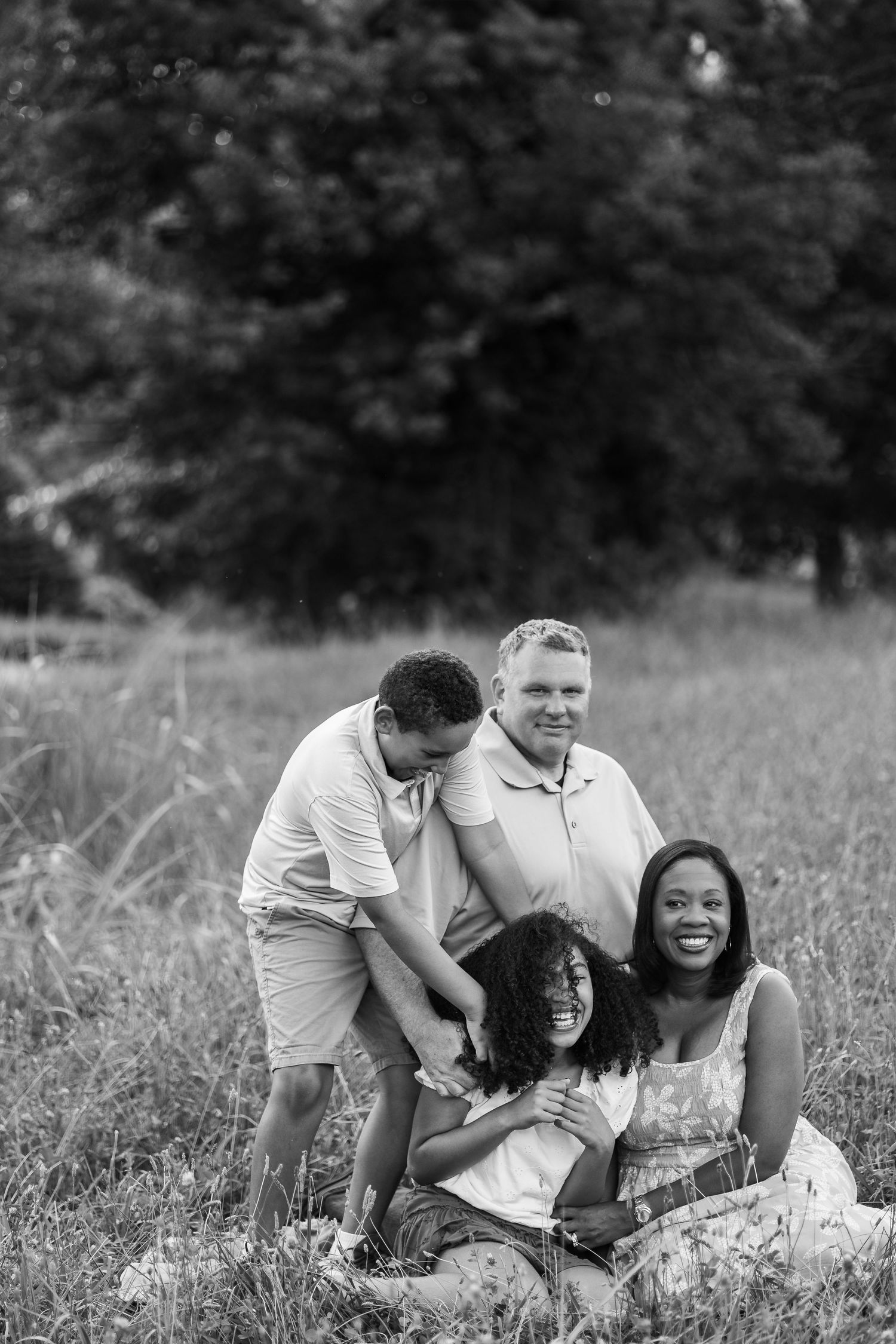 People playing and having fun together while rolling on grass in a field.