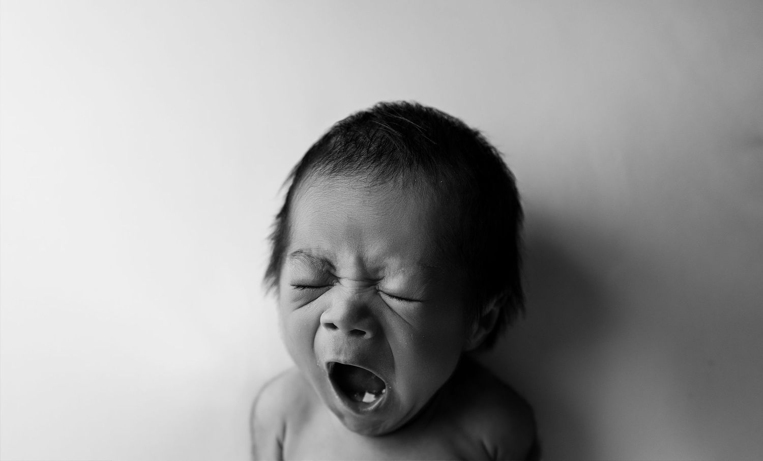 A black and white photo showing three expressions of yawning, capturing the contagious nature of yawns.