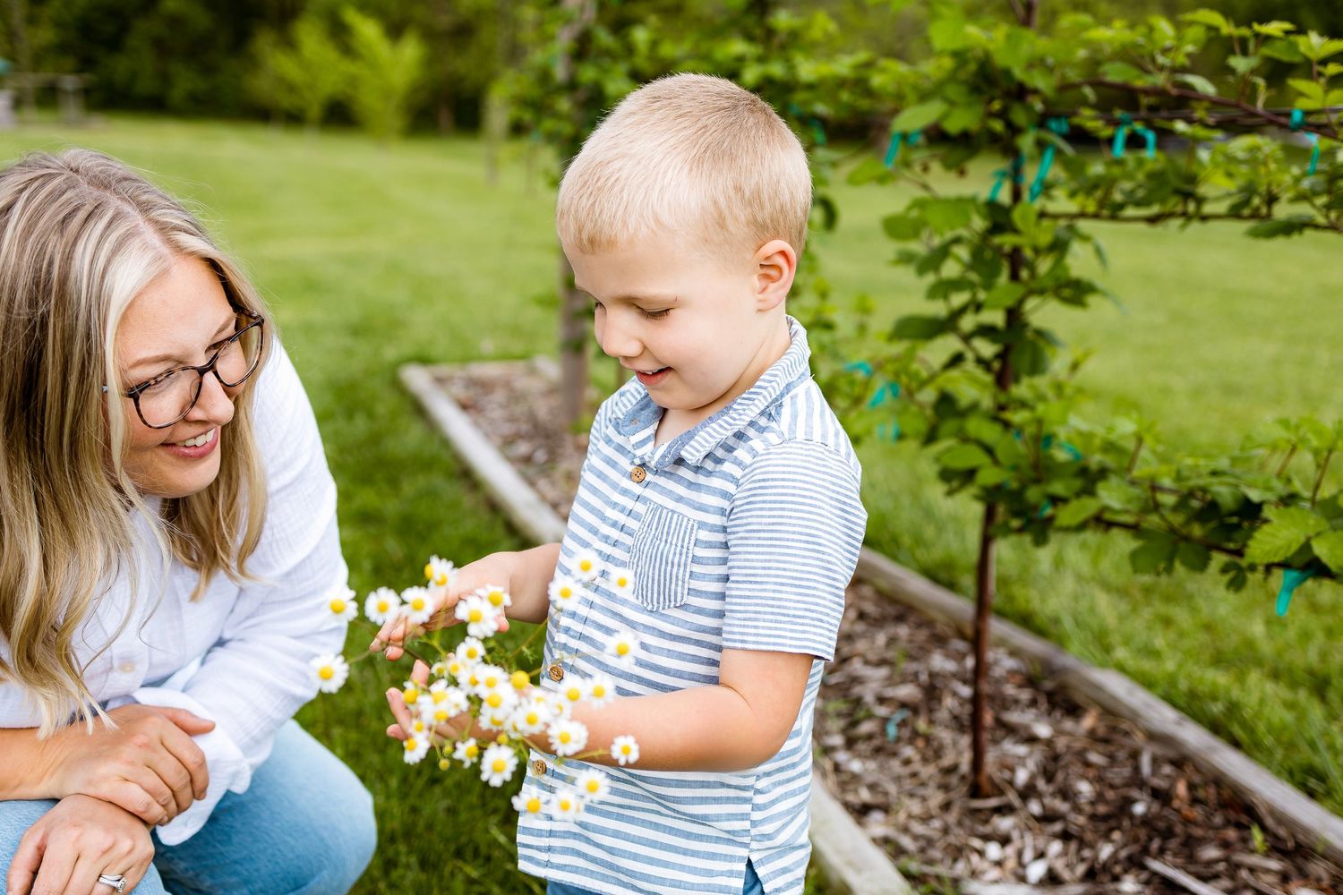 Spring garden scene with flowers as child and adult share a joyful moment.
