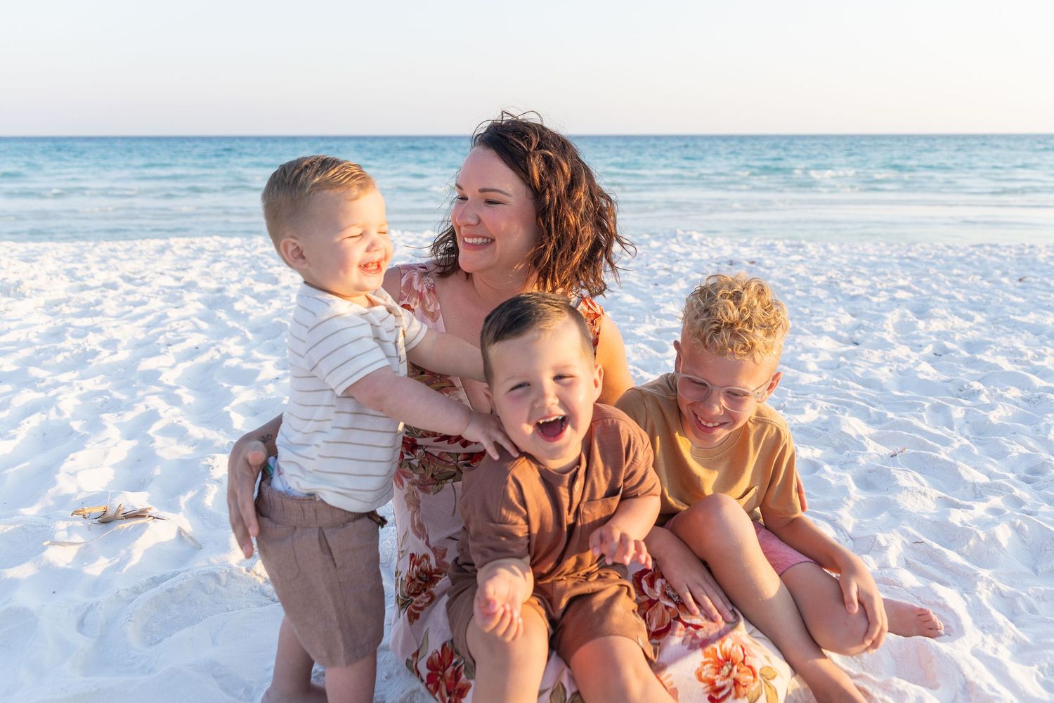 Happy group enjoying a sunny day at the white sandy beach with ocean backdrop.