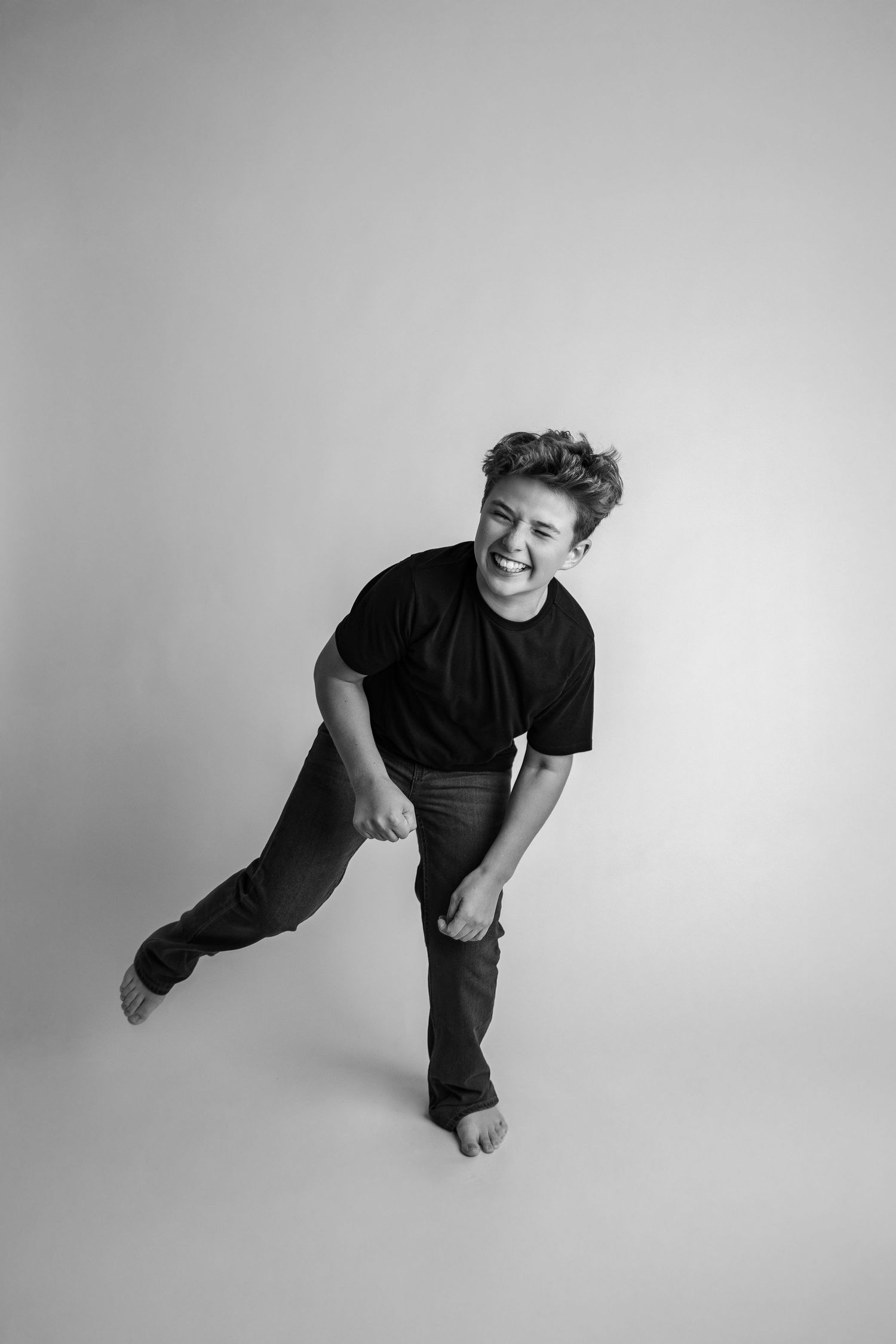 A sequence of black and white photos showing a person in dark clothing performing dynamic dance-like movements.