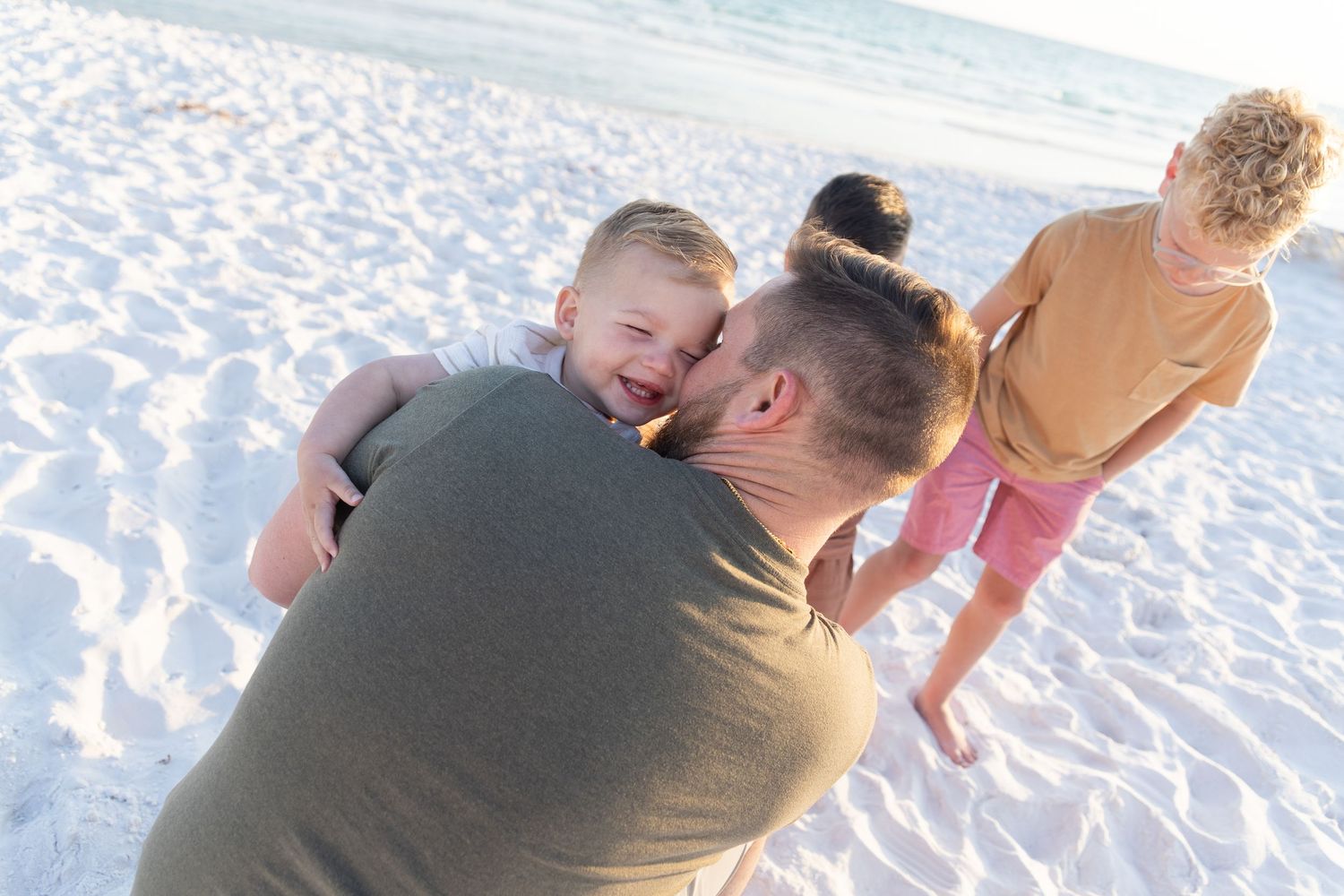 Playful beach moment captured during sunset with white sand background.