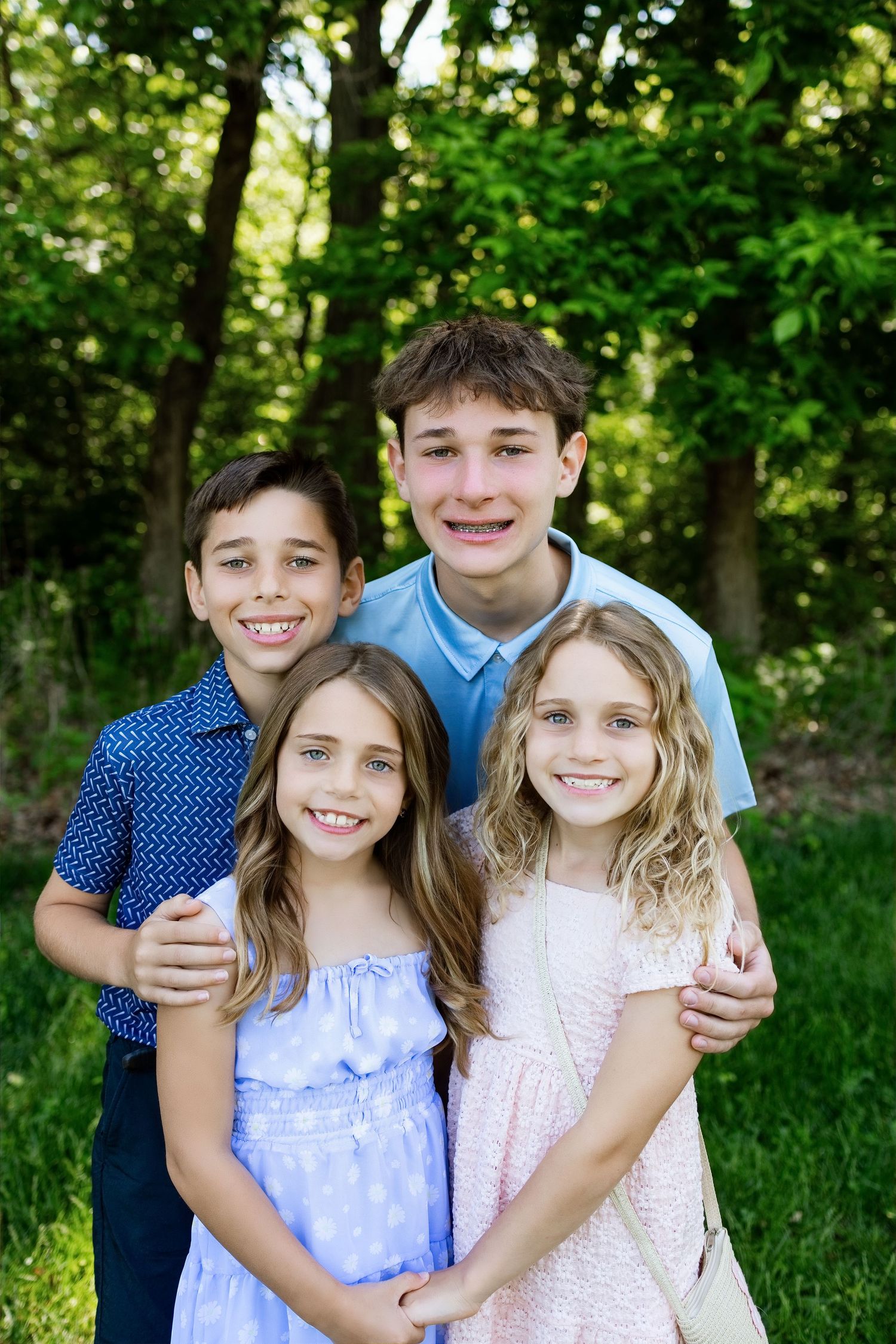 Four siblings smiling together during a summer family photography session in Southern Illinois