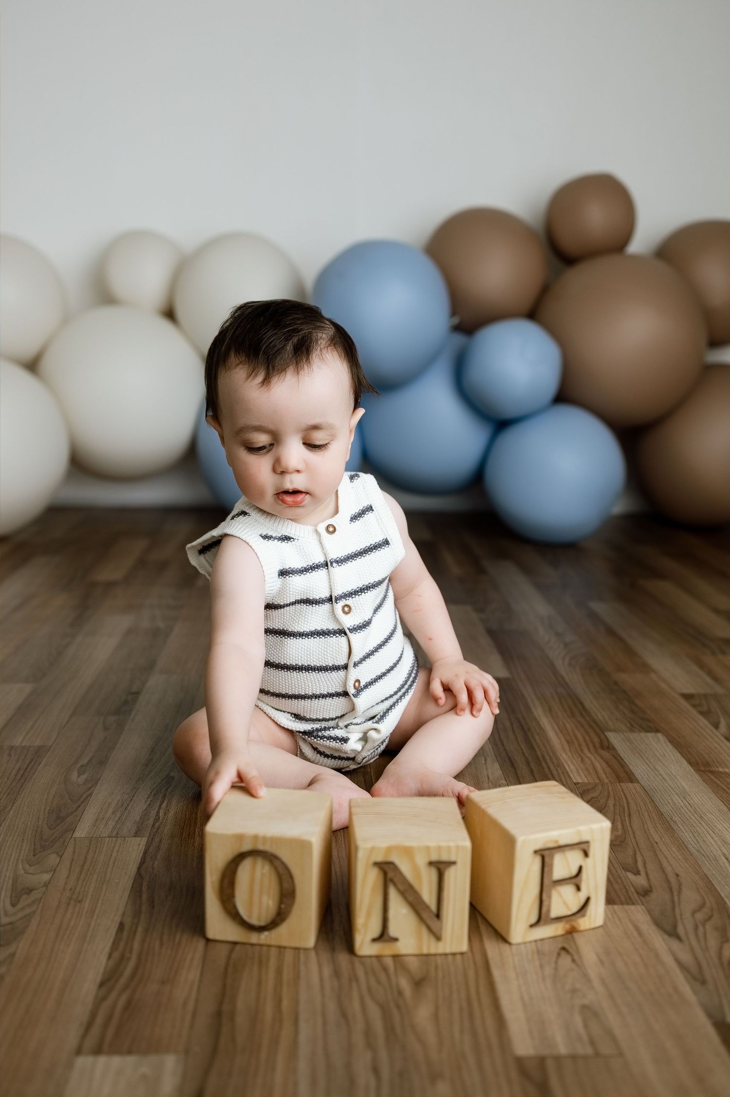 One-year-old baby posed with balloons and wooden ONE blocks during an Edwardsville cake smash session