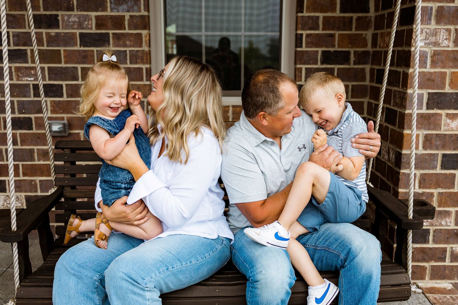 A family sharing joyful moments together on a porch swing.