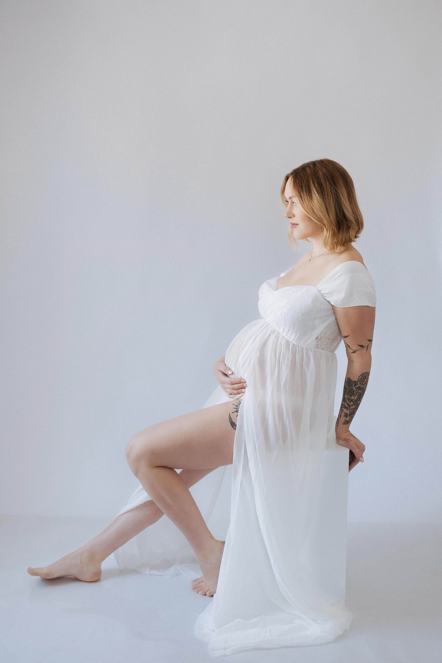 Artistic portrait series of a figure in flowing white fabric against a light background.