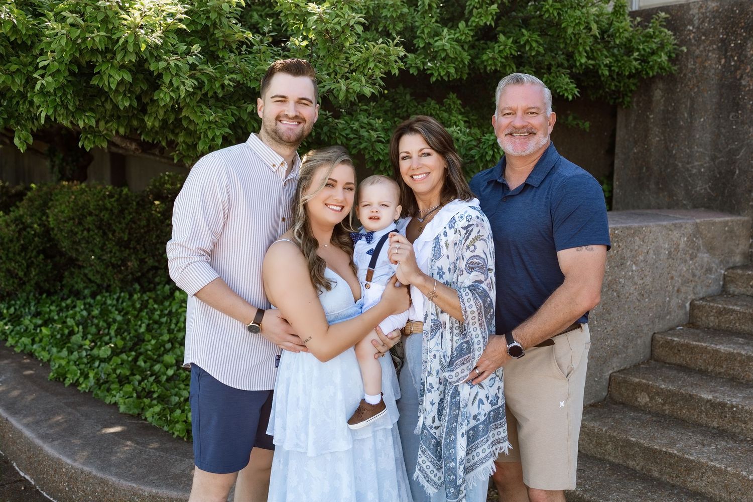 Family of five smiling together during a multigenerational family photography session in the Metro East area