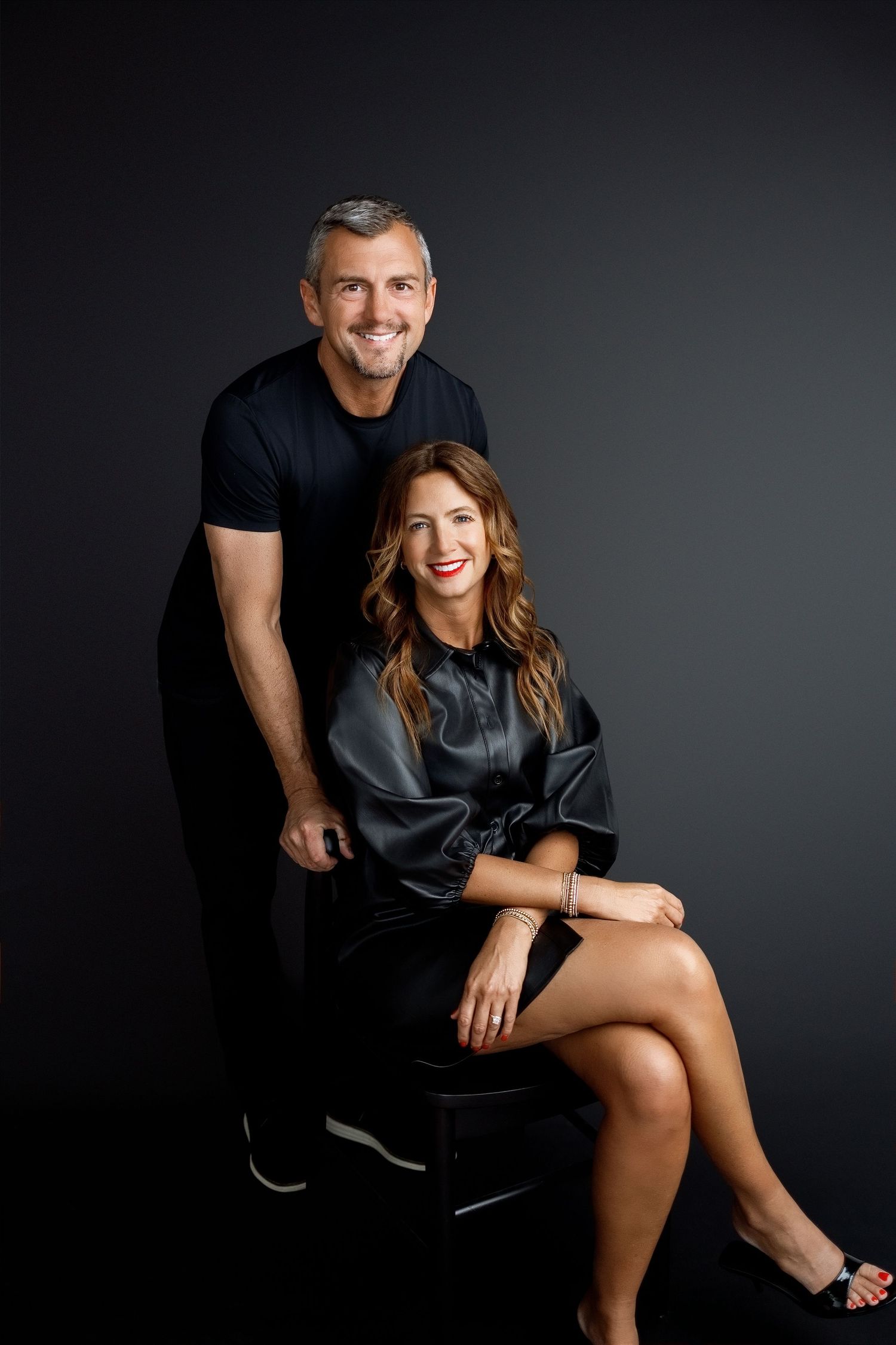 Podcast co-hosts photographed in a dramatic seated portrait for their professional brand imagery