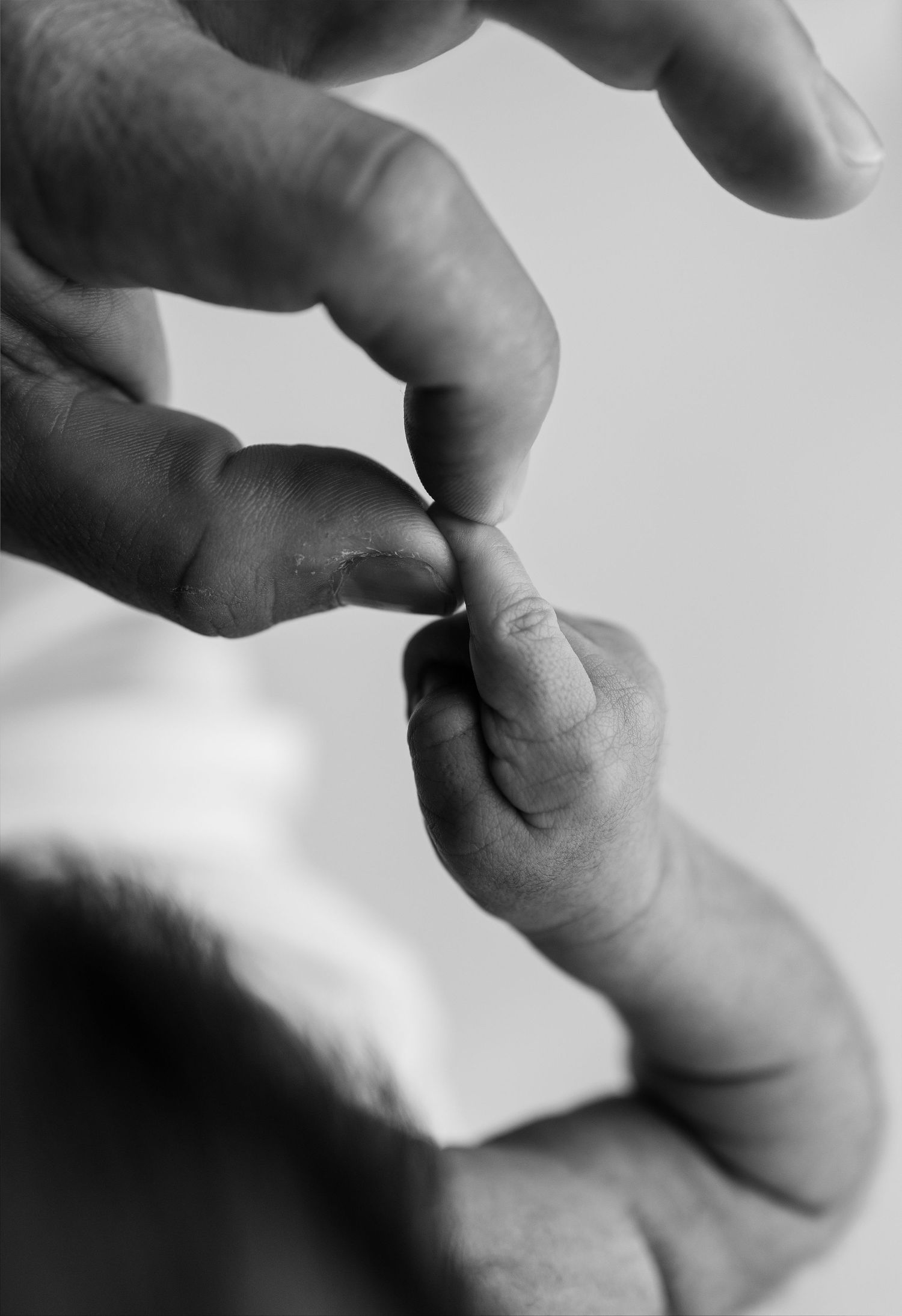 Close-up series of fingers touching in black and white showing gentle contact and connection.