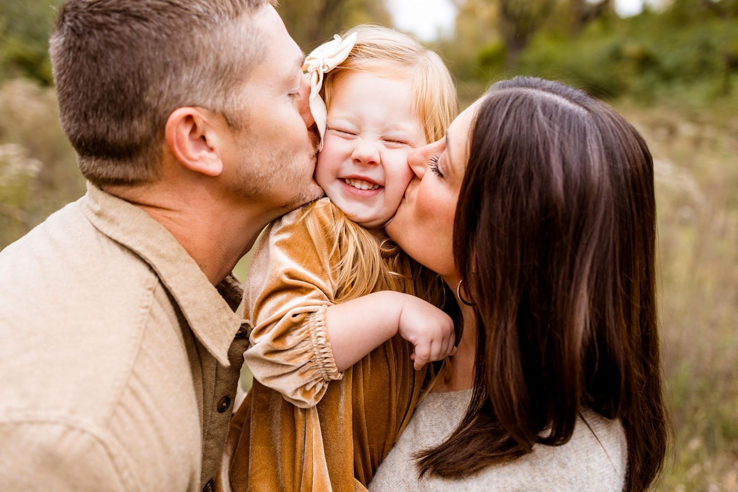 Happy couple embraces outdoors in a natural setting with warm autumn lighting.