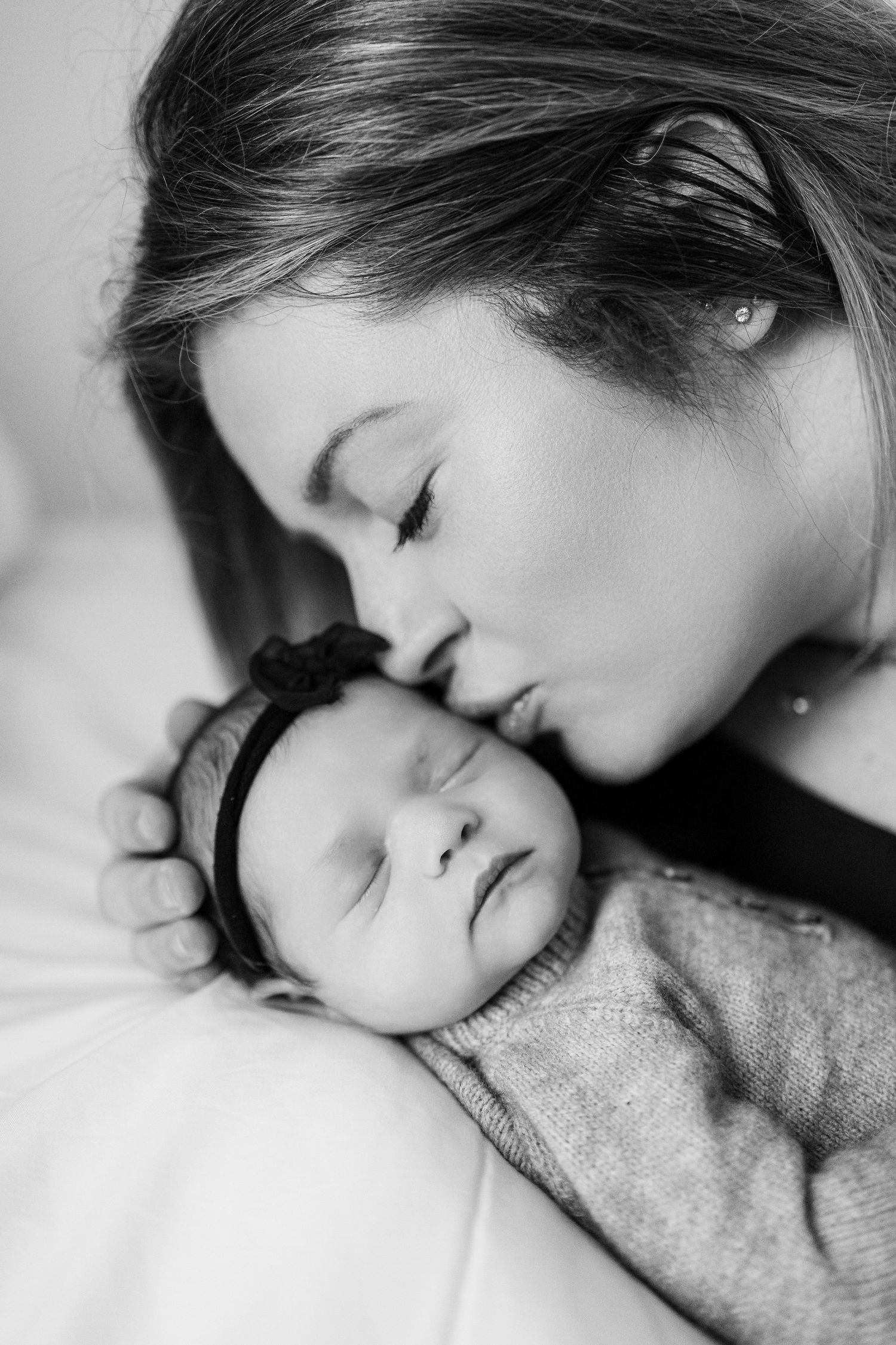 A tender black and white portrait of a sleeping baby being gently embraced in a heartwarming moment.