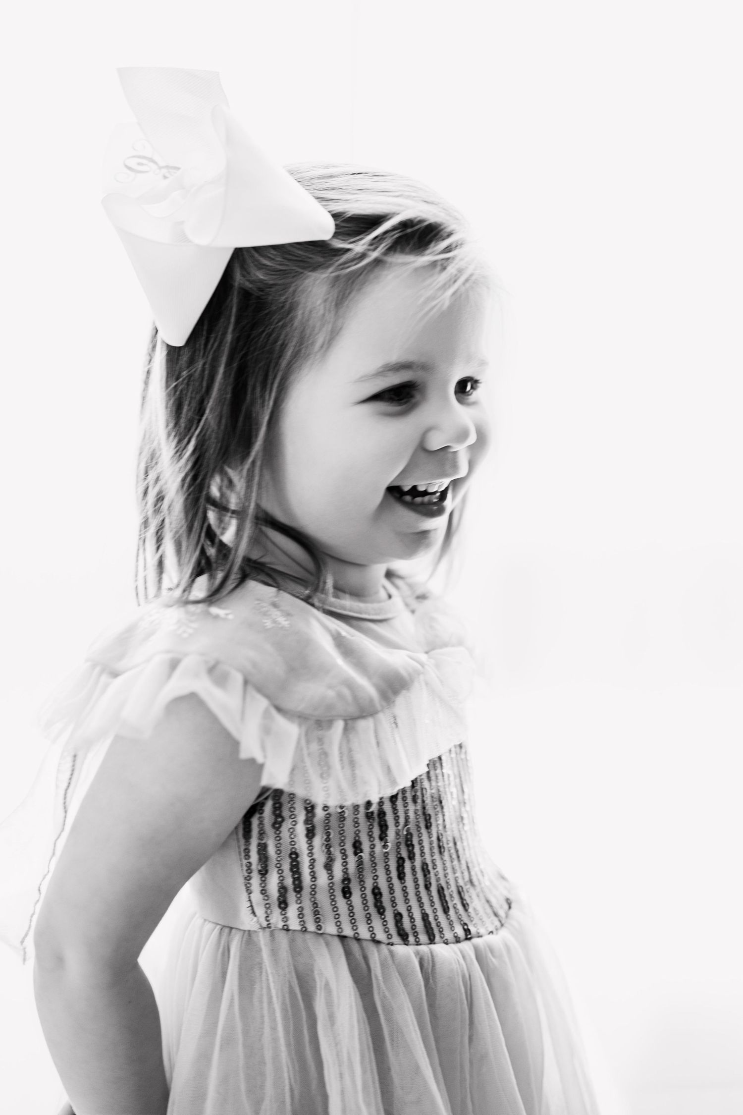 A series of black and white portraits showing joyful expressions and movement in a white dress.