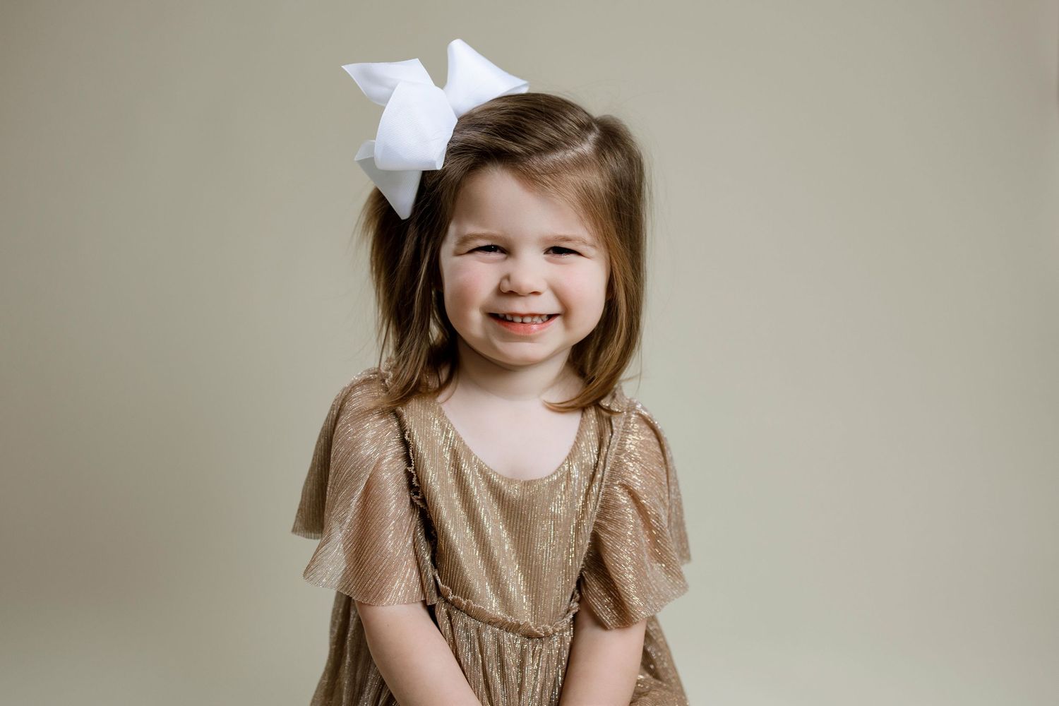 A sequence of seven similar photos showing a young person in a beige dress against a neutral background.