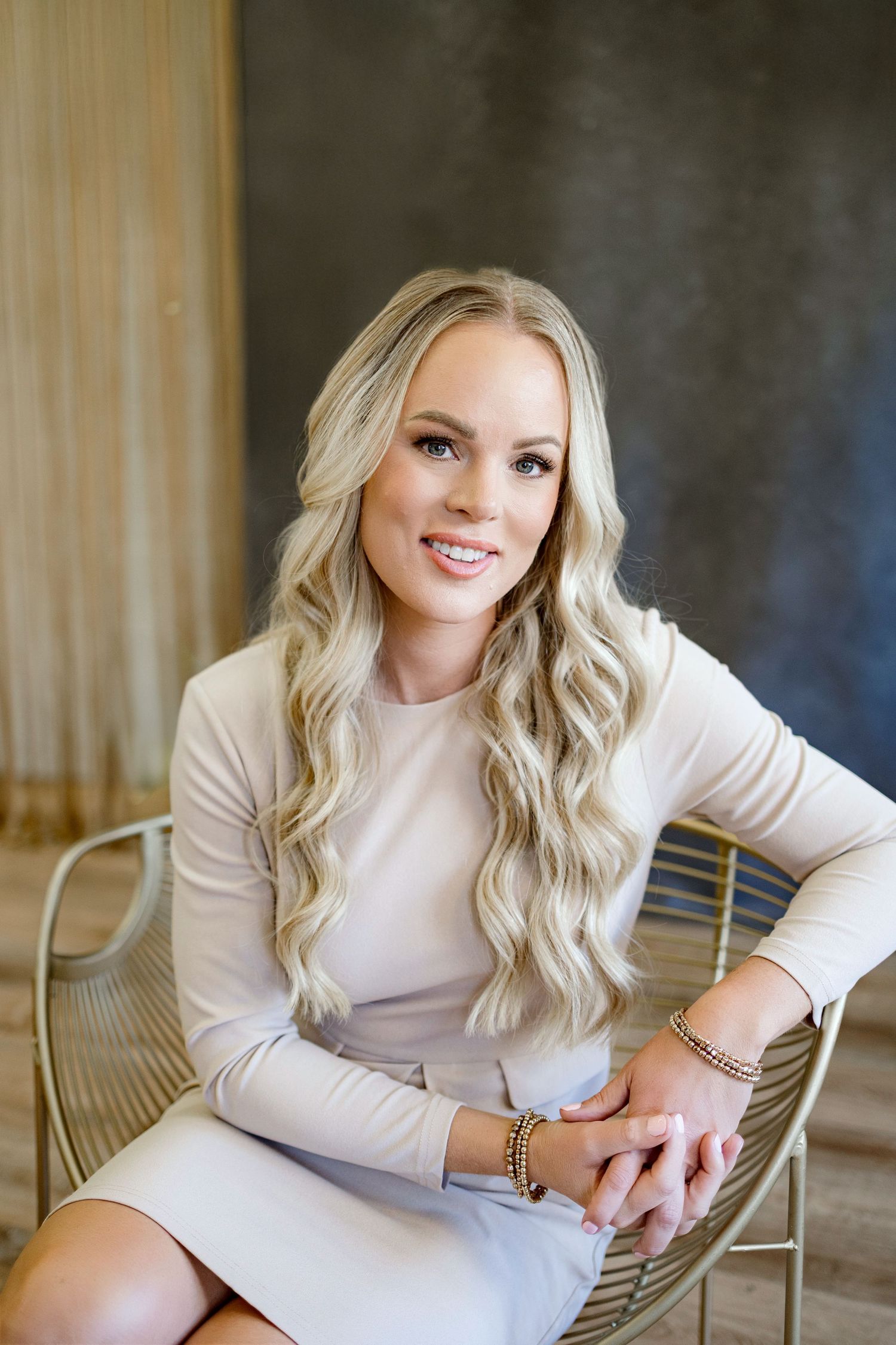 Lifestyle portrait session featuring cream colored sweater and elegant jewelry in warm indoor setting.