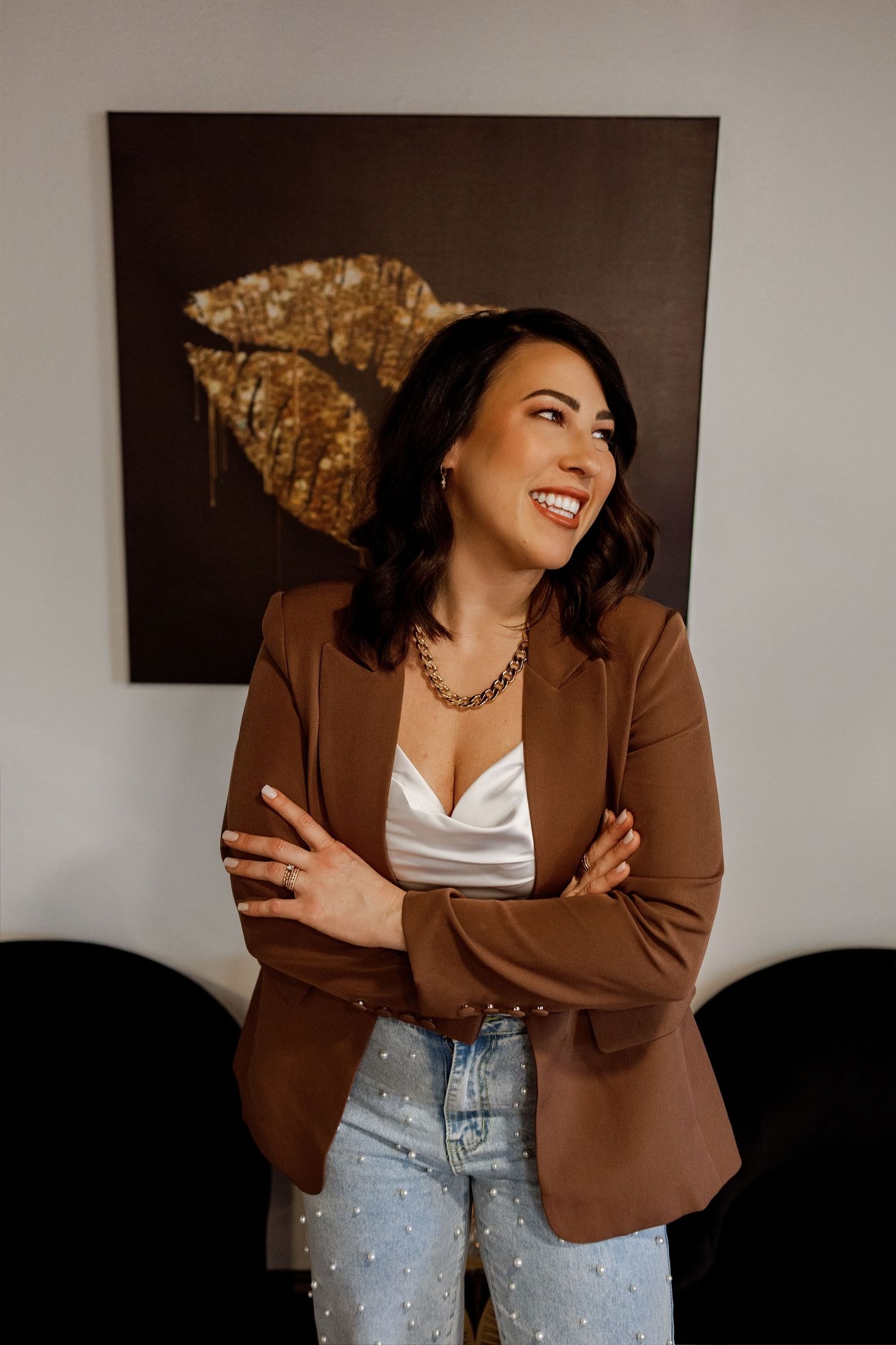 A series of fashion portraits showing a brown blazer paired with light denim jeans and a white top in different poses.