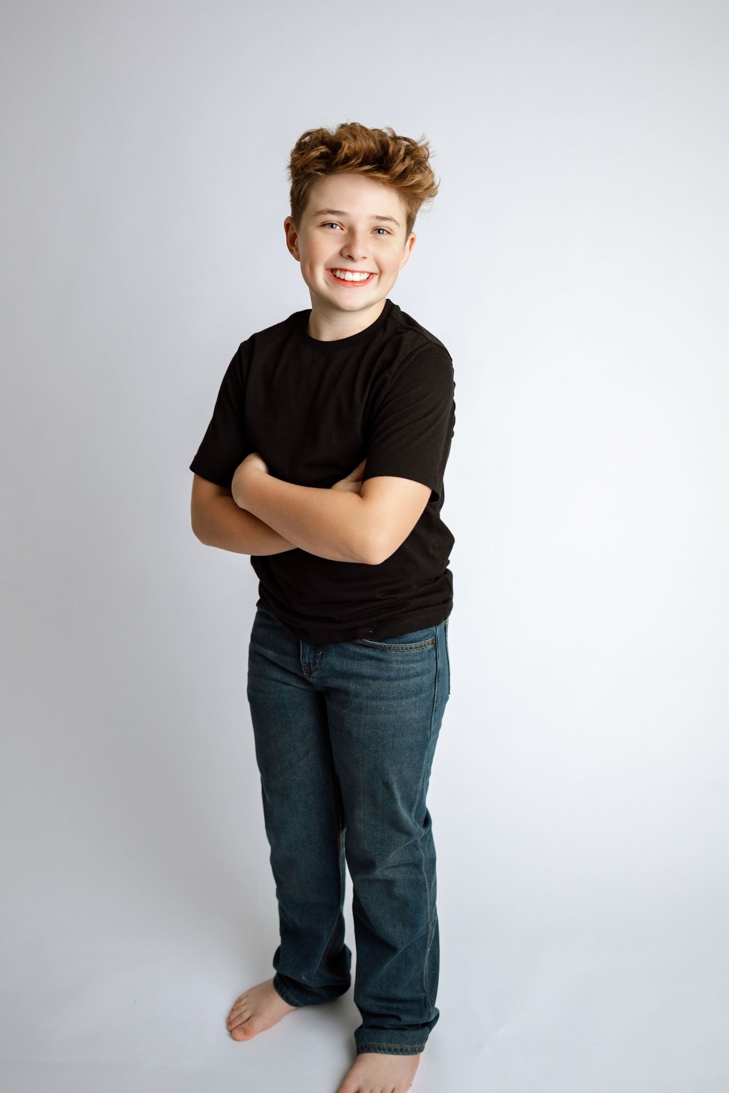 A series of four casual studio portraits showing someone in a black t-shirt and jeans against a white background.